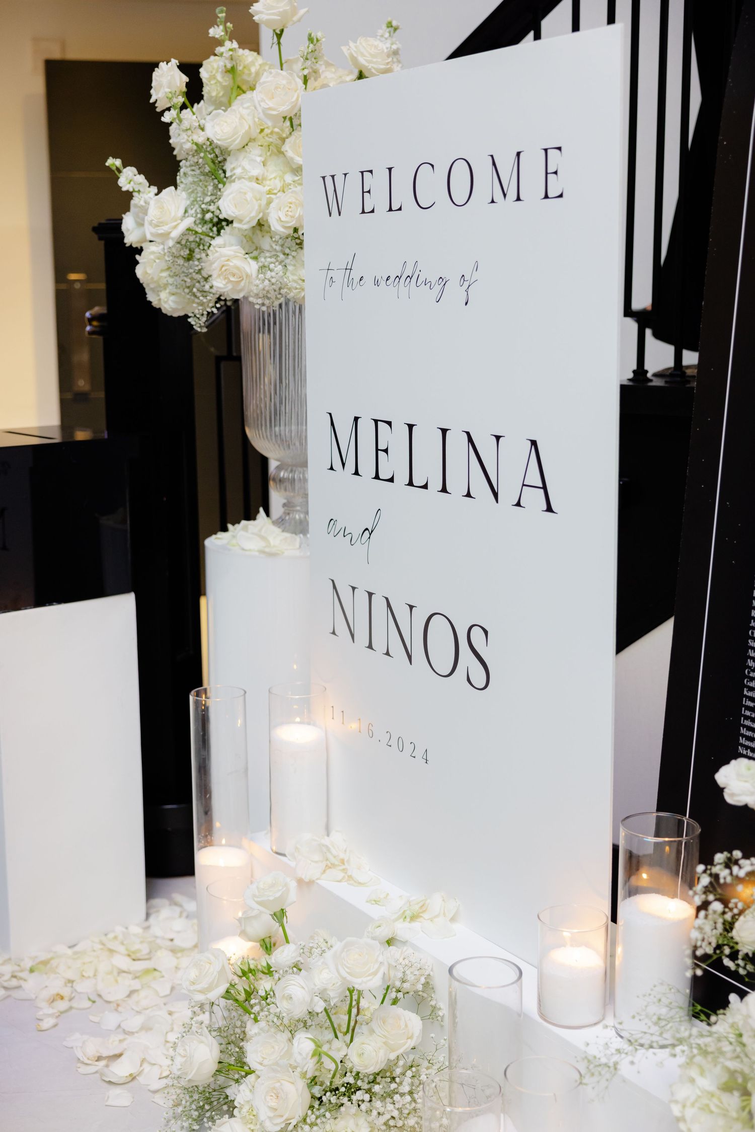 Welcome sign for wedding with white floral arrangements and candle decorations.