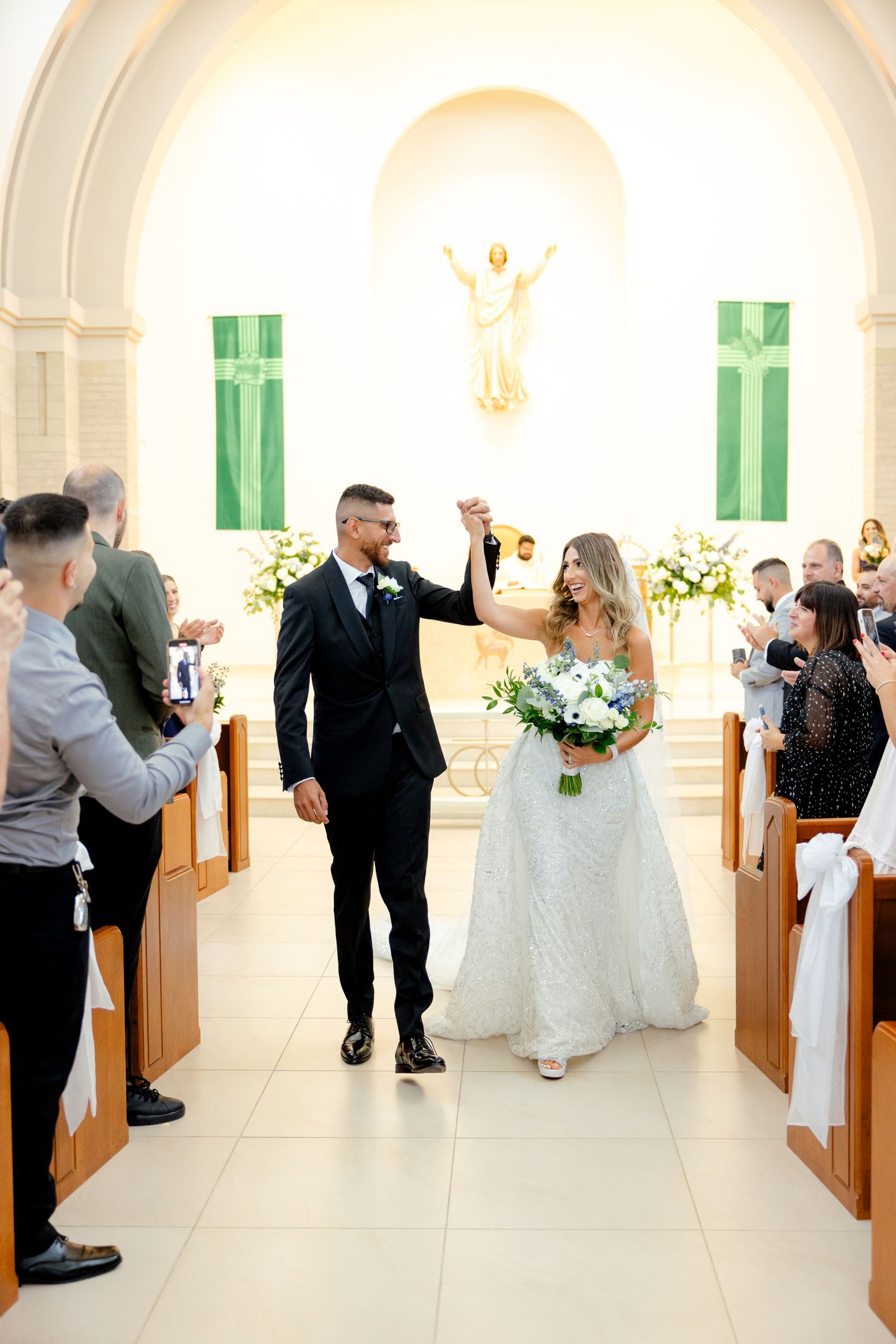 Joyful recessional down the church aisle with wedding guests celebrating.