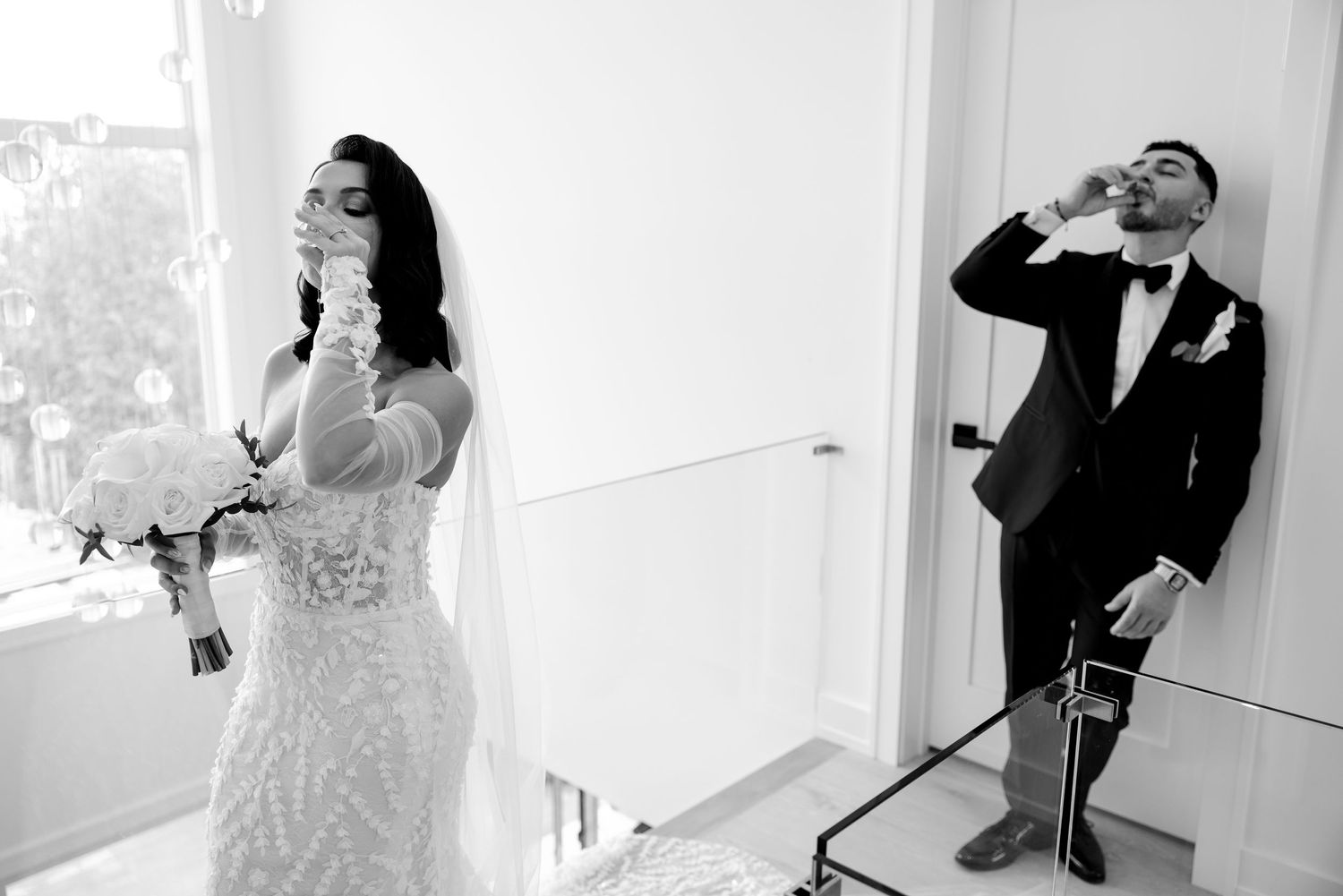 Wedding couple shares a playful moment in black and white photography.