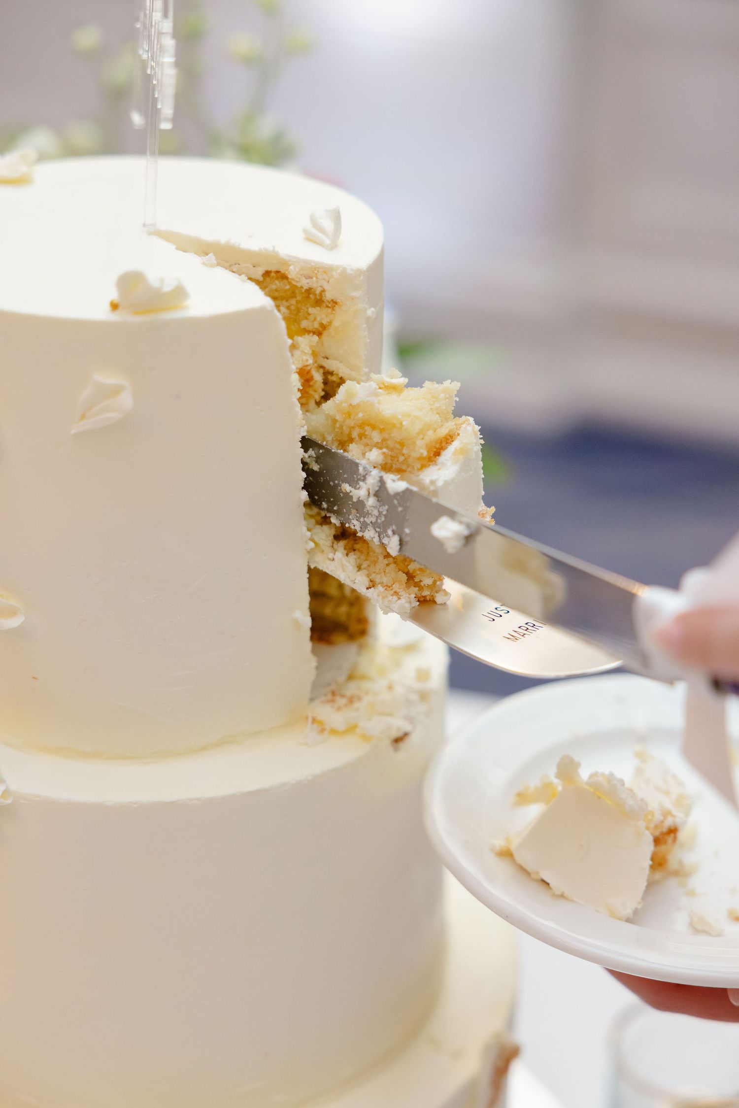 Close-up sequence showing a white wedding cake being cut into slices at an elegant reception.