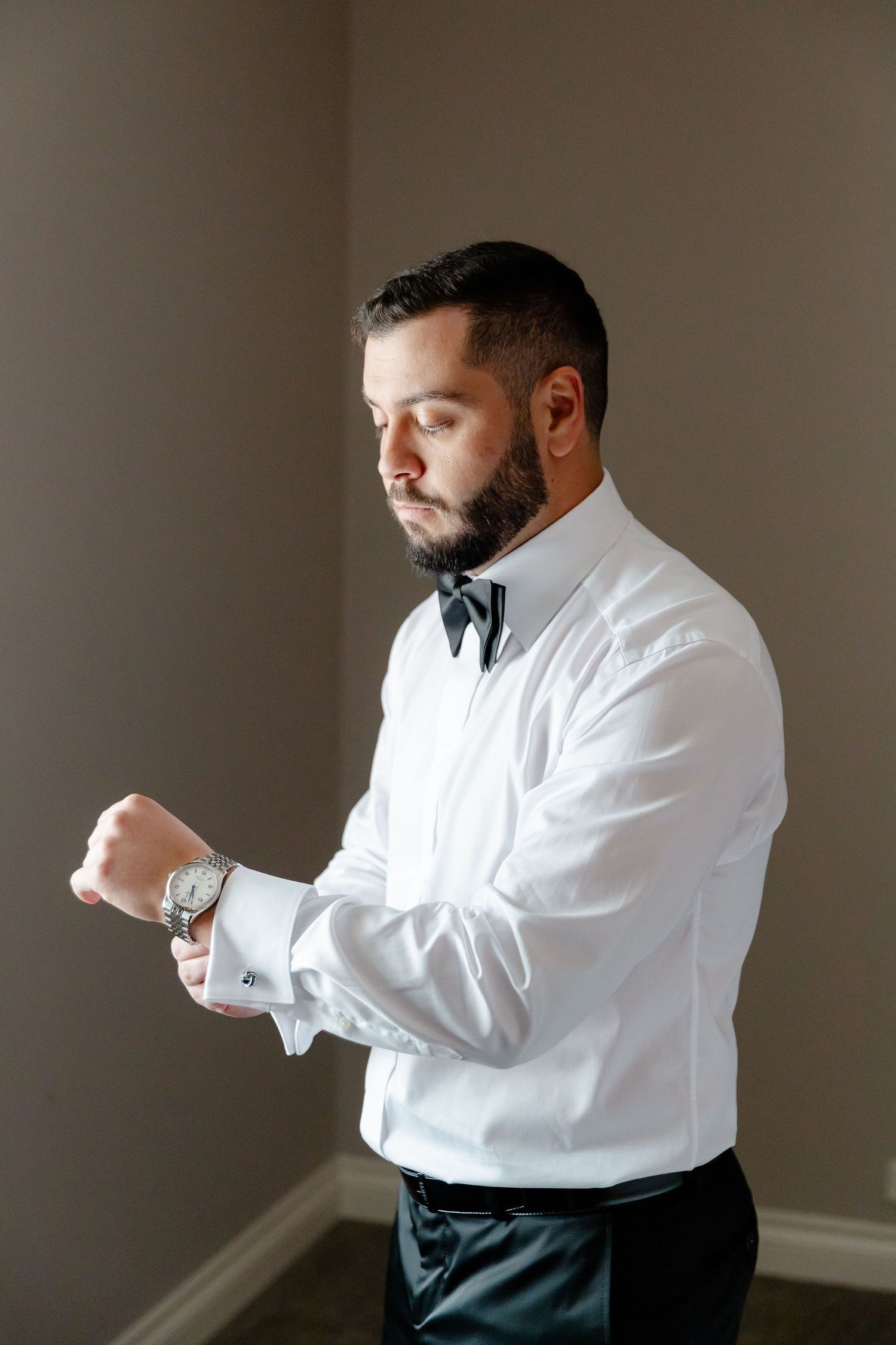 Sequence of someone adjusting their white dress shirt cuffs and sleeves in preparation for a formal event.
