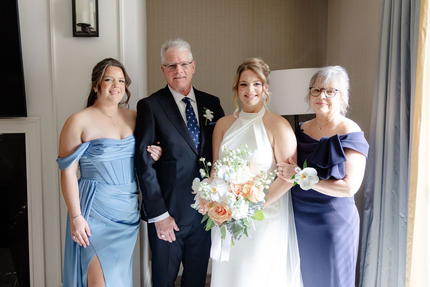 A joyful wedding party moment showing people in blue dresses and formal attire celebrating together.