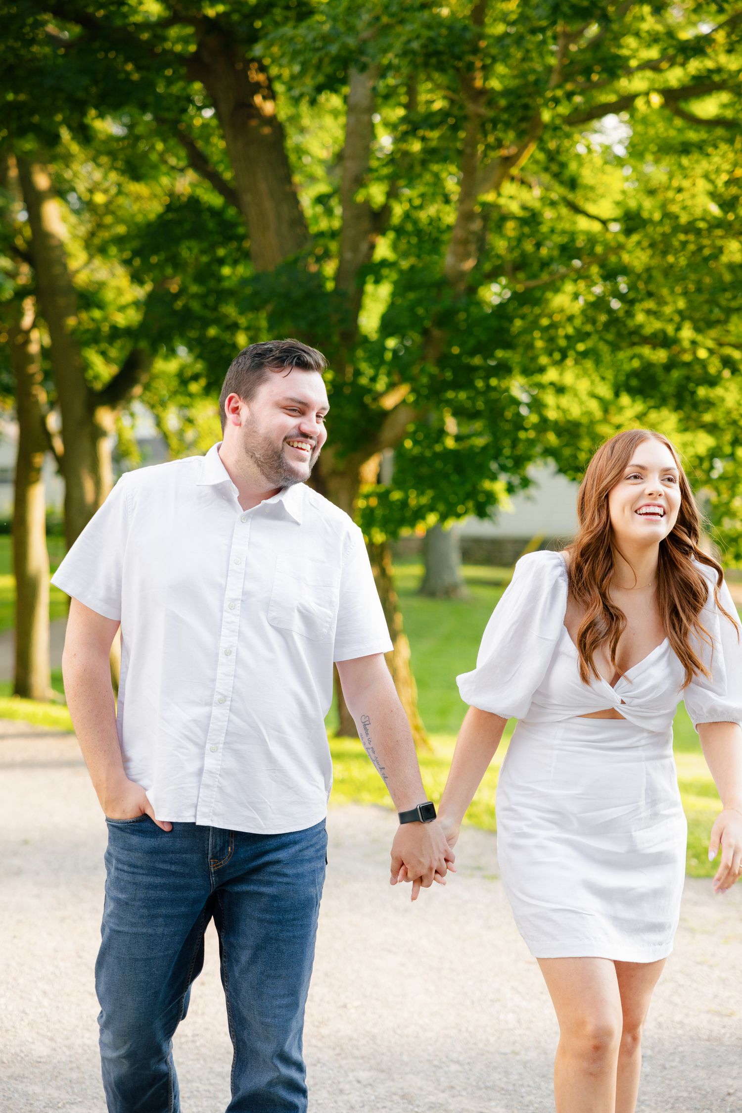 A happy couple sharing a joyful moment while walking through a park.