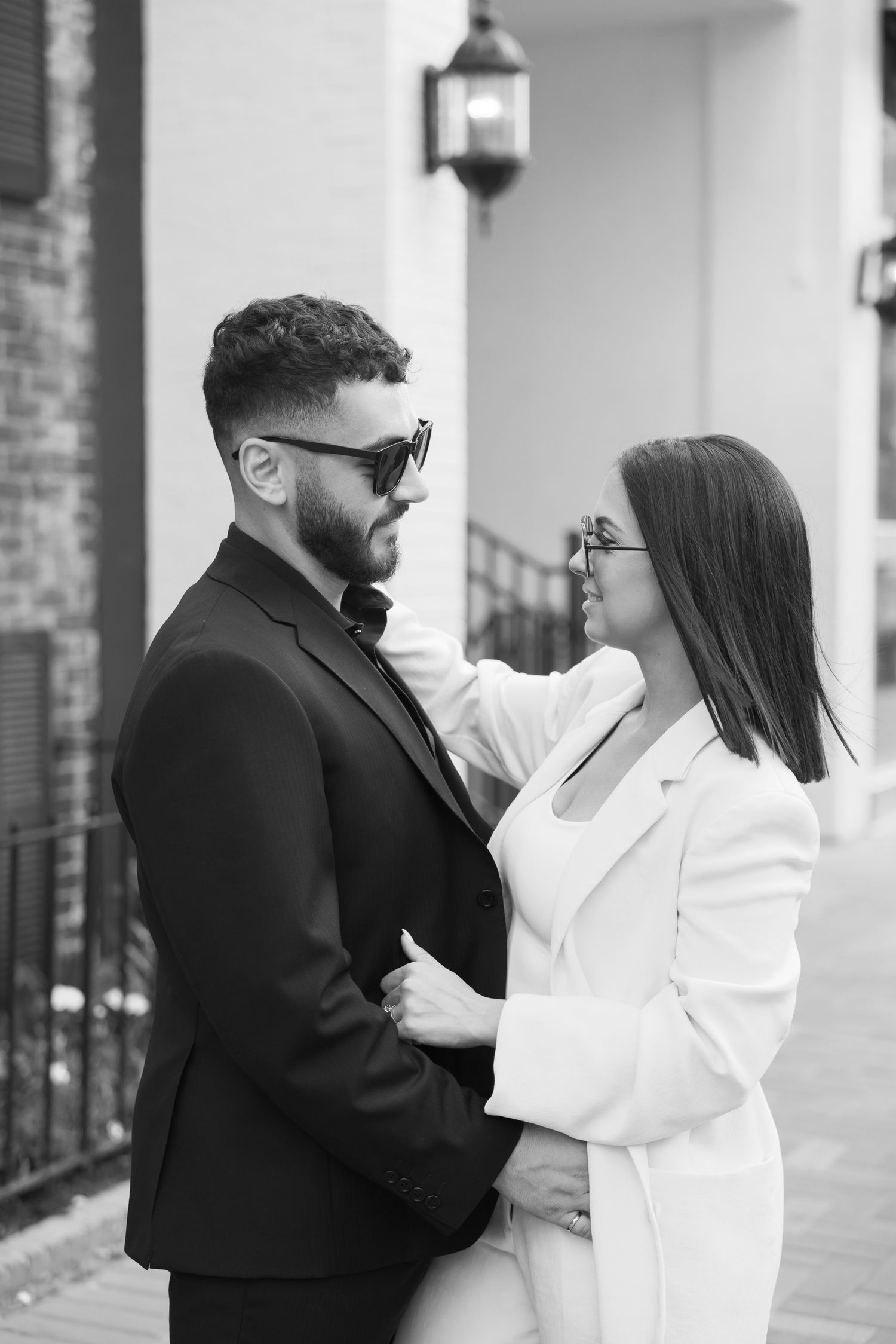 A romantic black and white portrait of a stylish couple in contrasting black and white formal attire.
