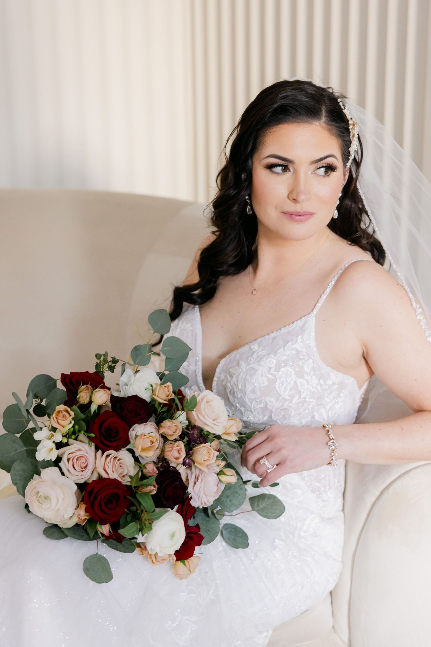 Classic bridal portrait featuring lace dress and burgundy rose bouquet.