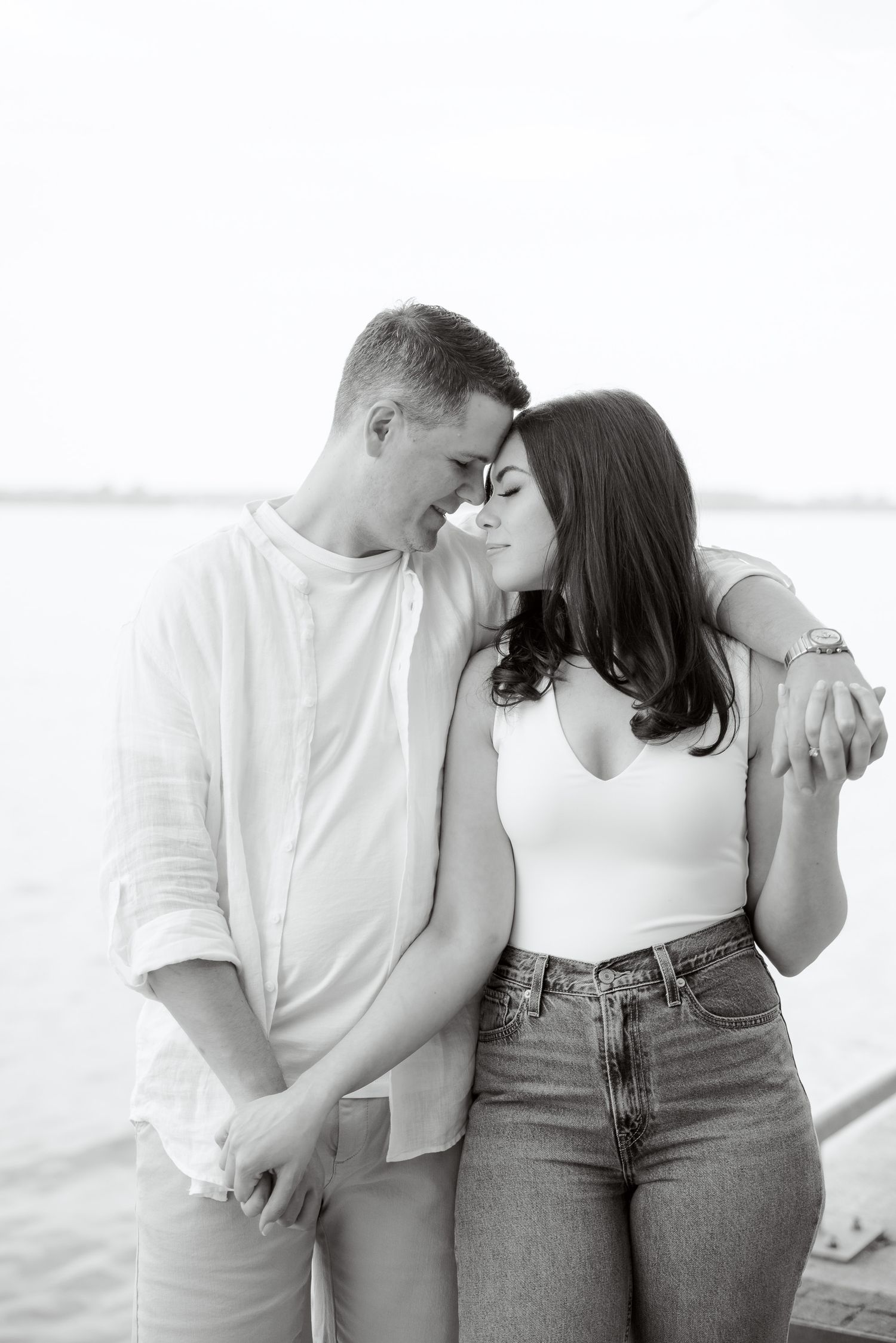 A tender black and white moment captured between a couple by the water.