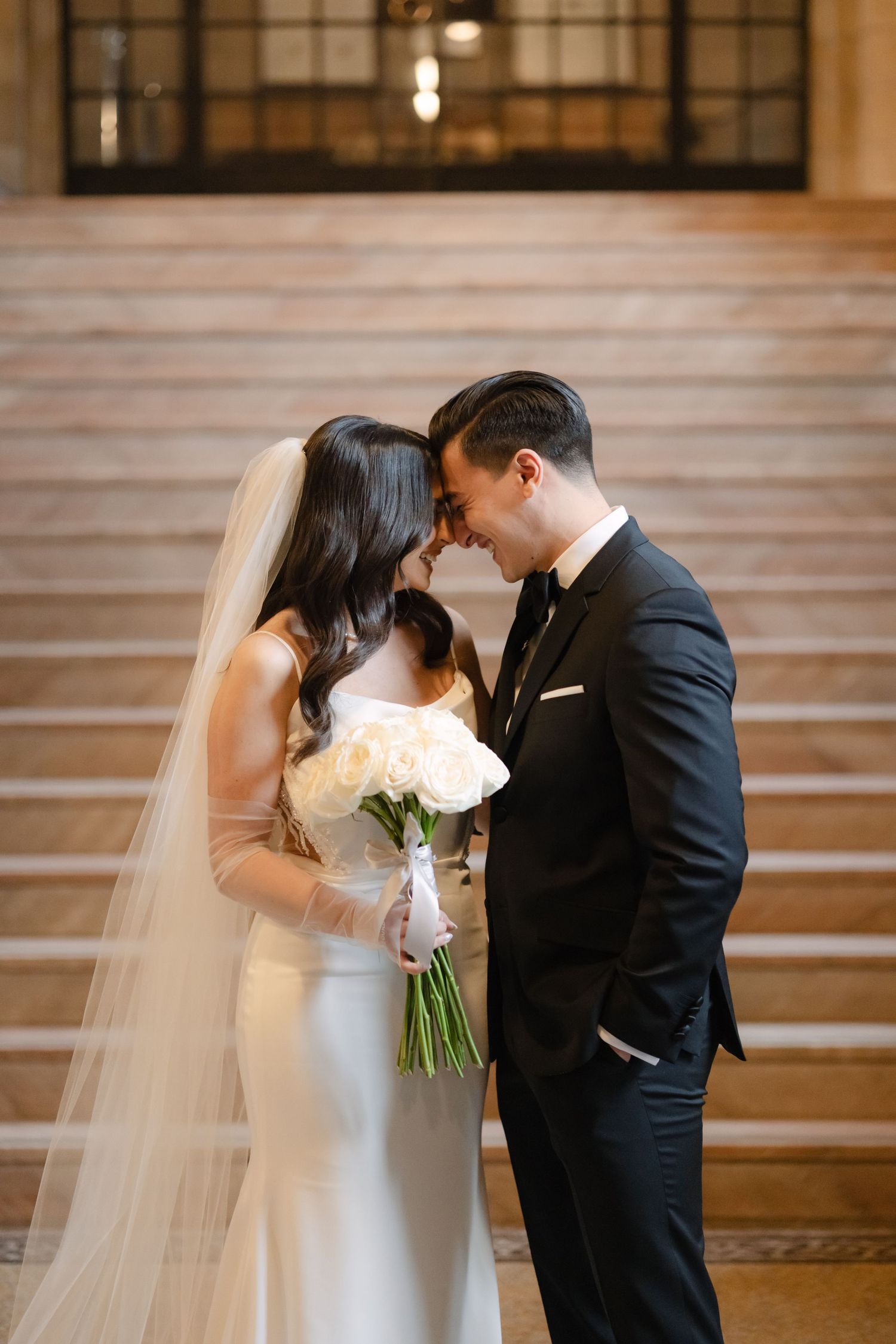 An intimate wedding moment with white roses against the backdrop of stone stairs.