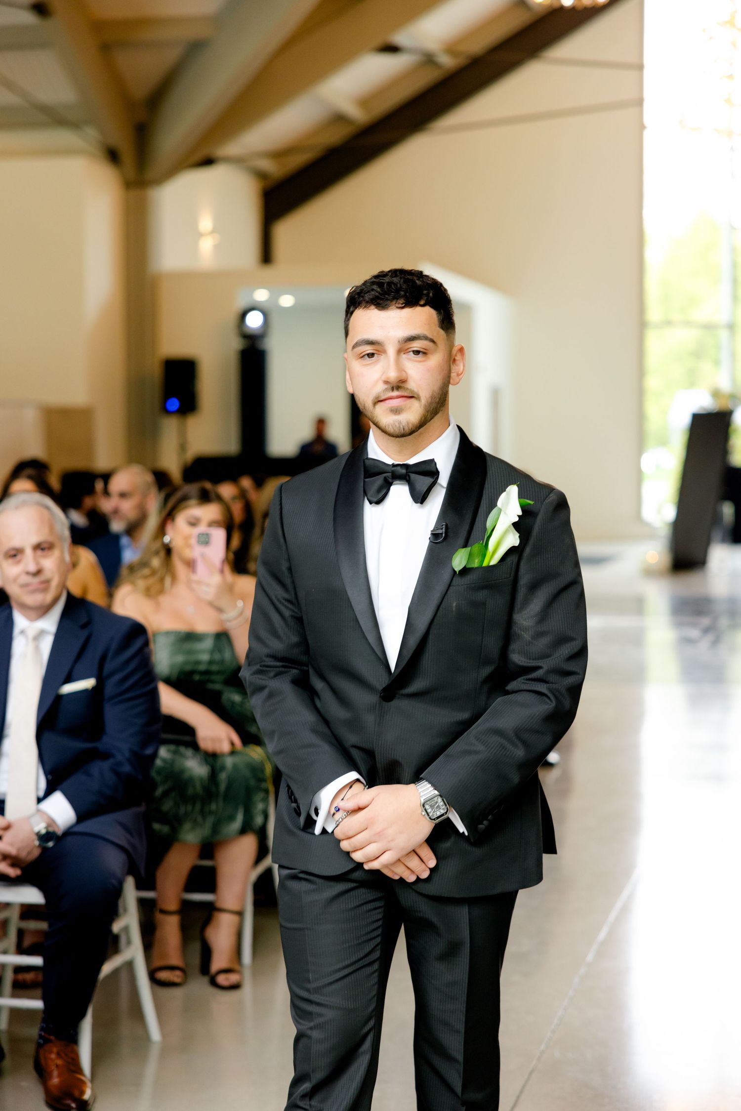 Wedding ceremony in modern venue with elegant decor and clear windows.