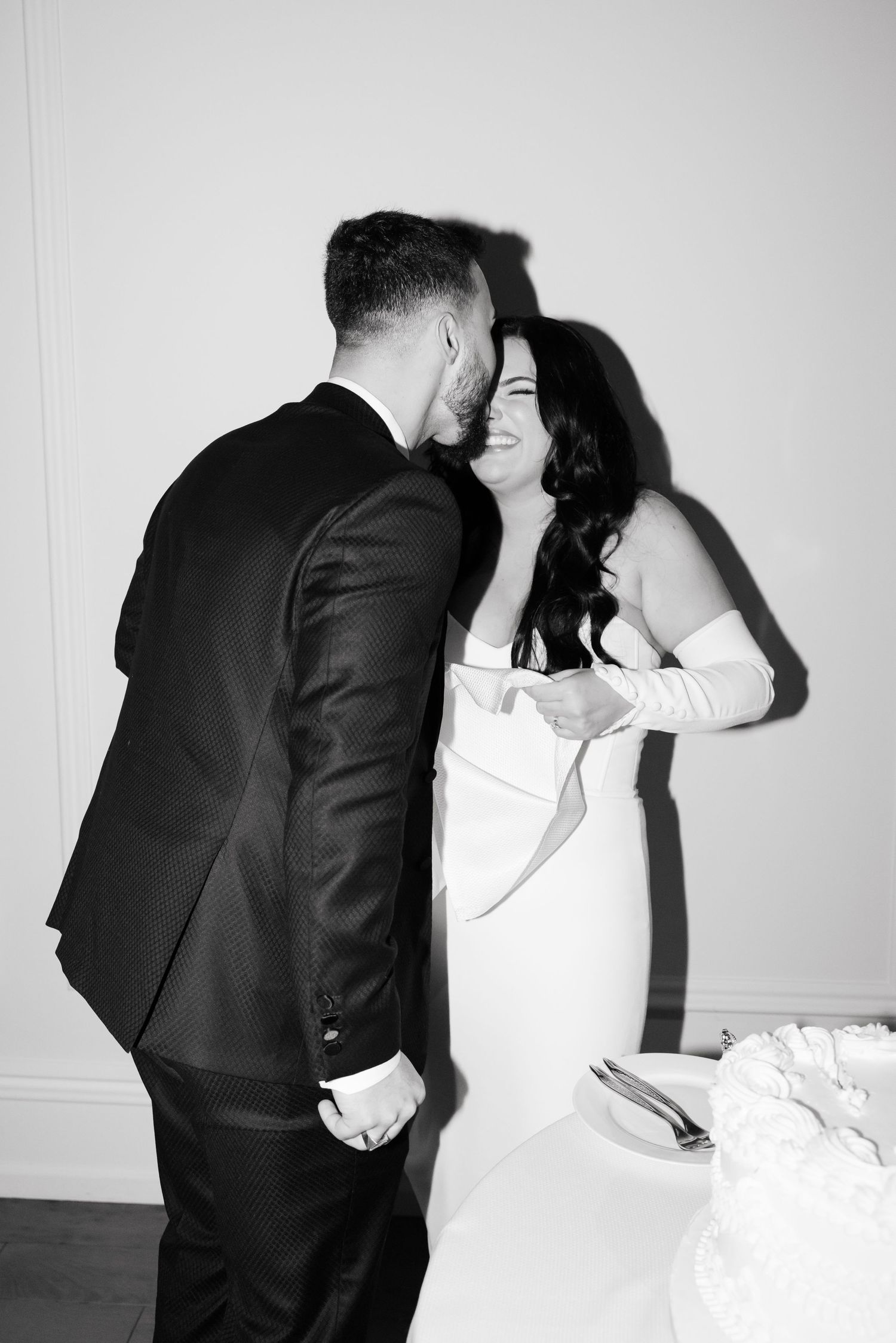 Black and white photo capturing a tender moment between newlyweds.