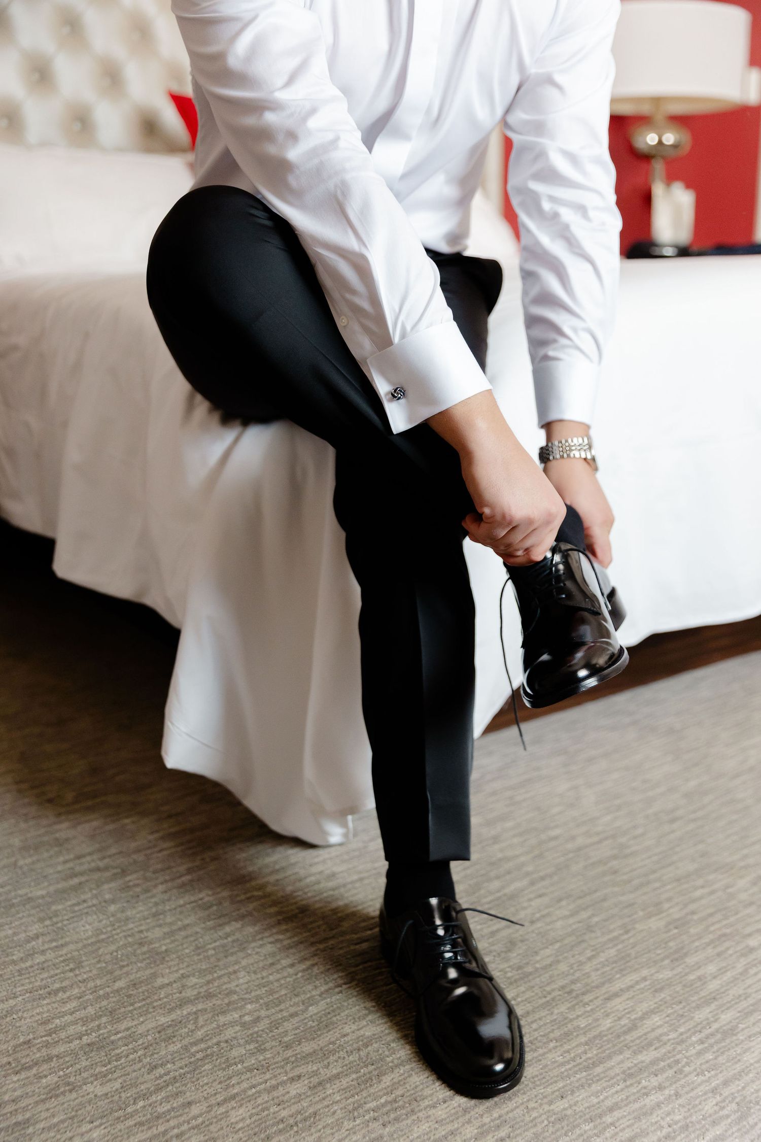 Close-up shots of formal black dress shoes being put on with white shirt and black pants visible.