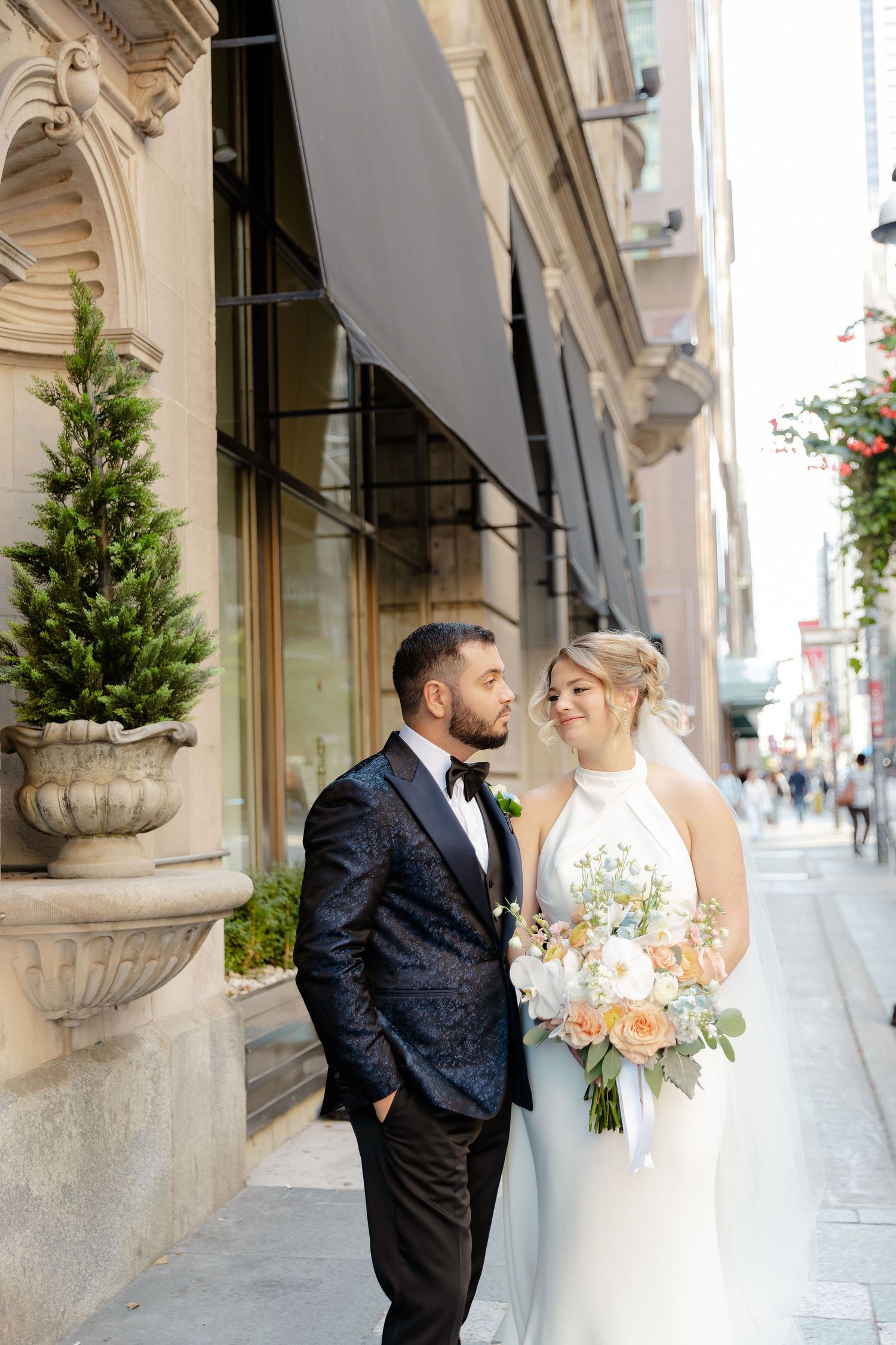 Elegant wedding portraits along historic architecture with floral bouquet and classic attire.
