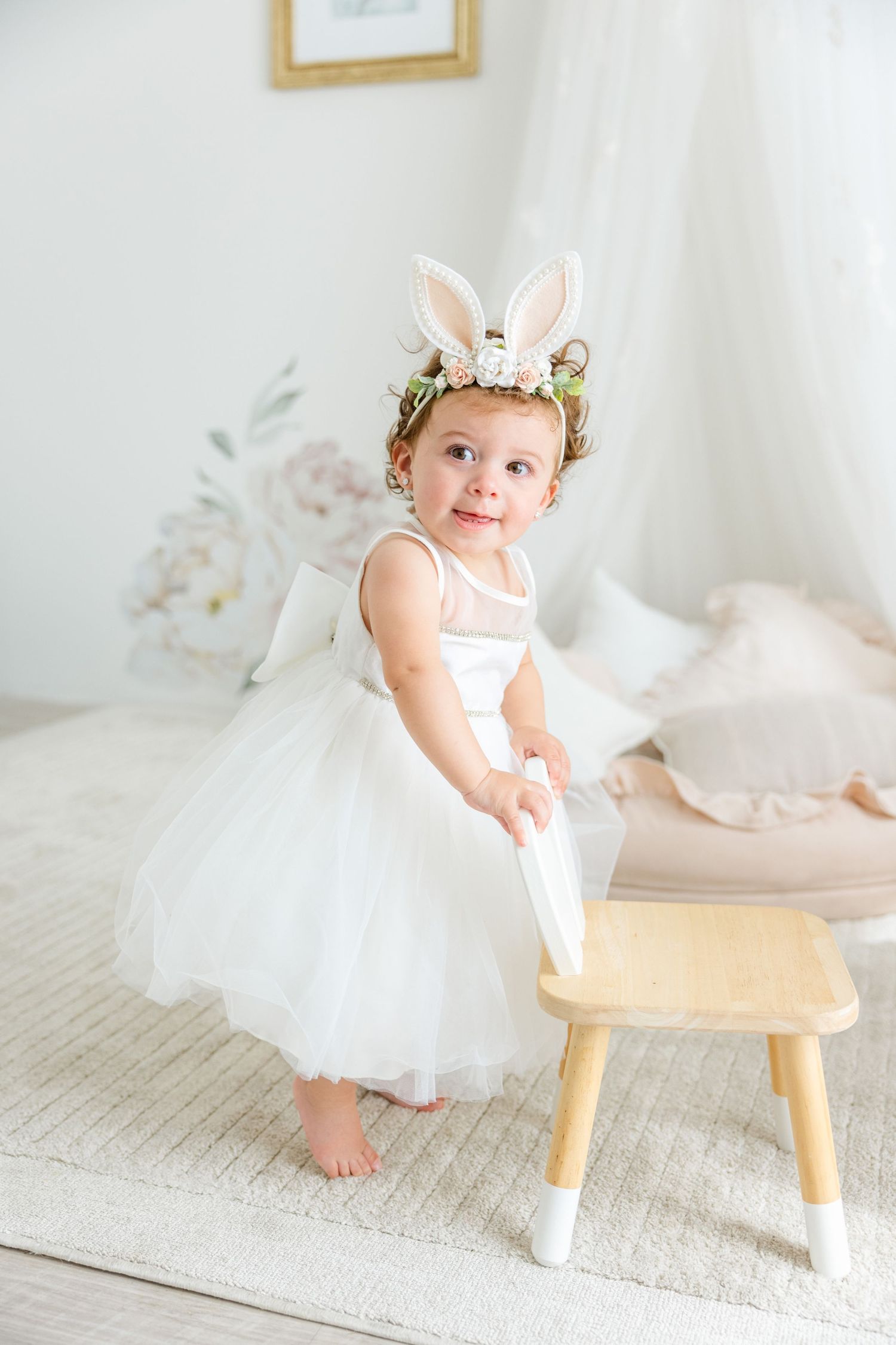 White tulle dress and bunny ear crown create magical scene in bright nursery setting.