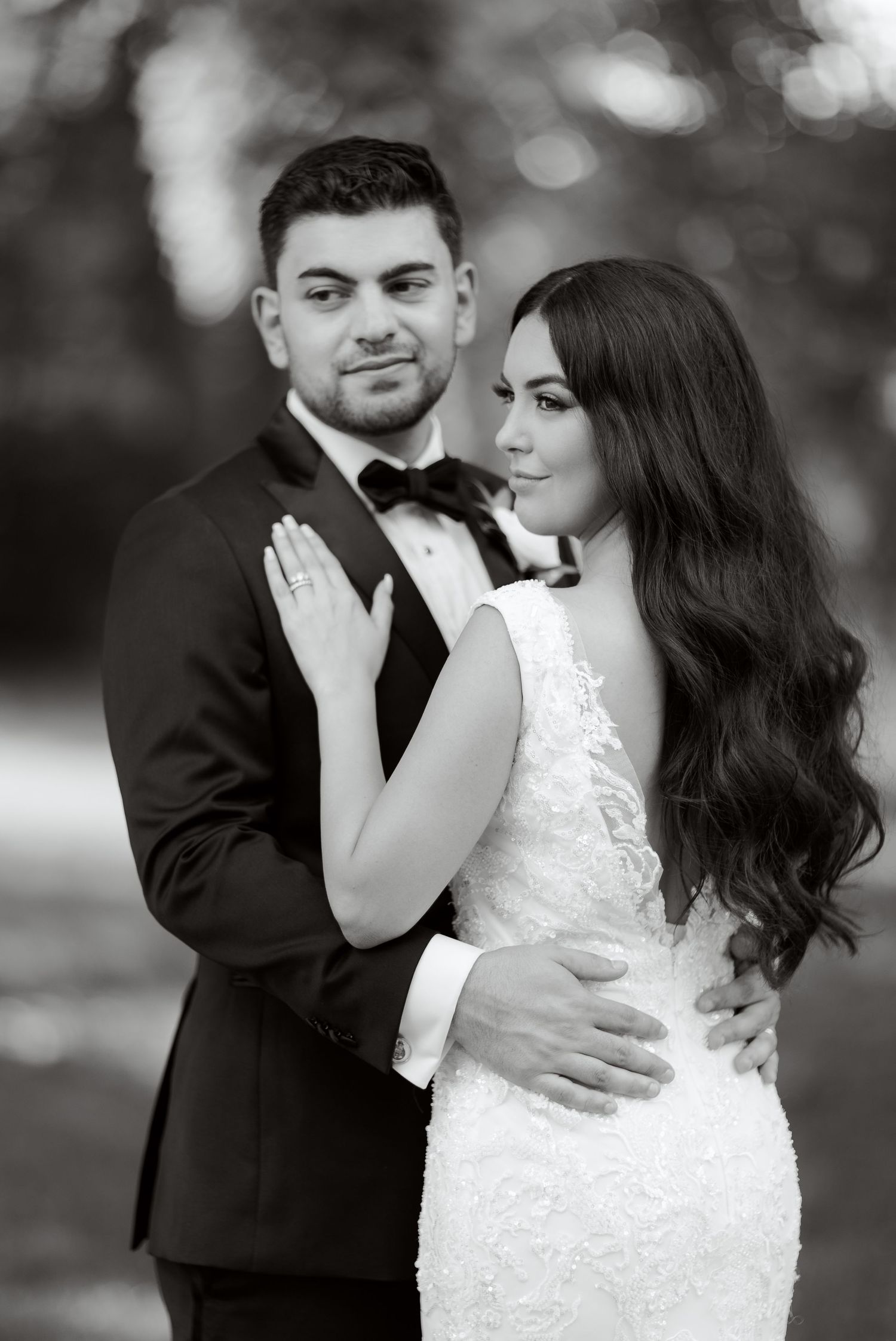 An elegant black and white portrait of newlyweds in formal wedding attire.