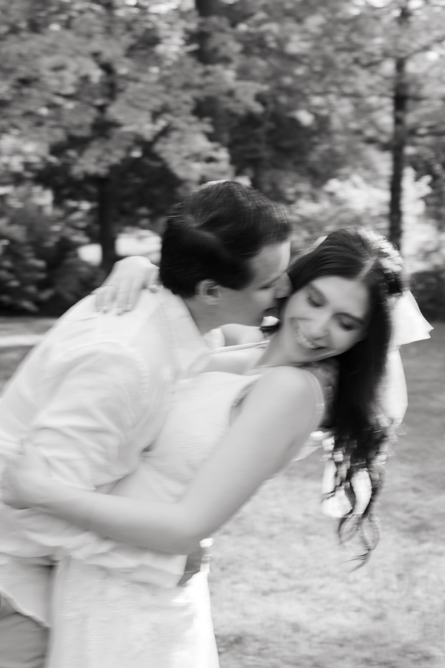 Artistic black and white portrait of a couple in an intimate dance-like pose.