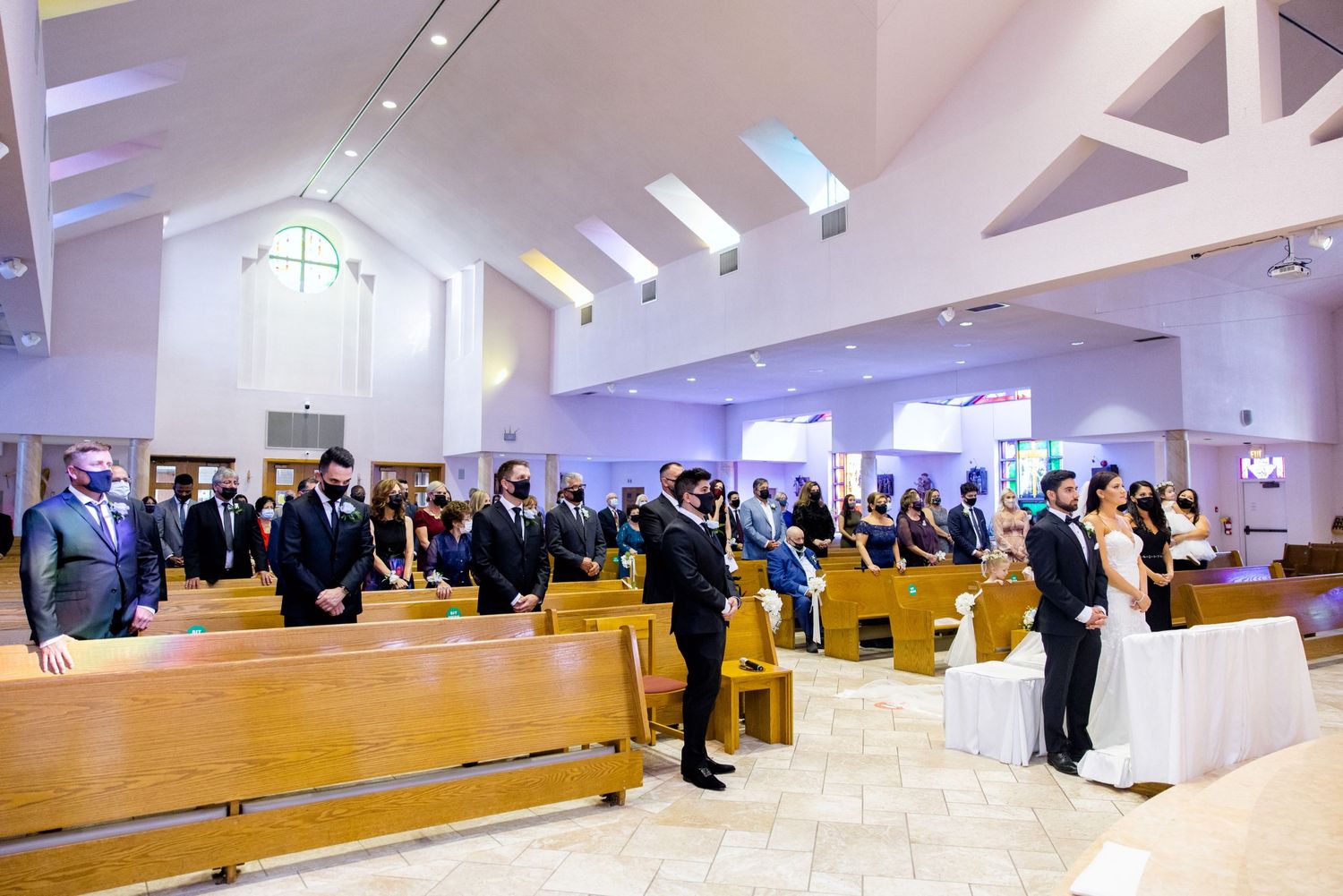 Wedding ceremony in a modern church with vaulted ceilings and natural lighting.