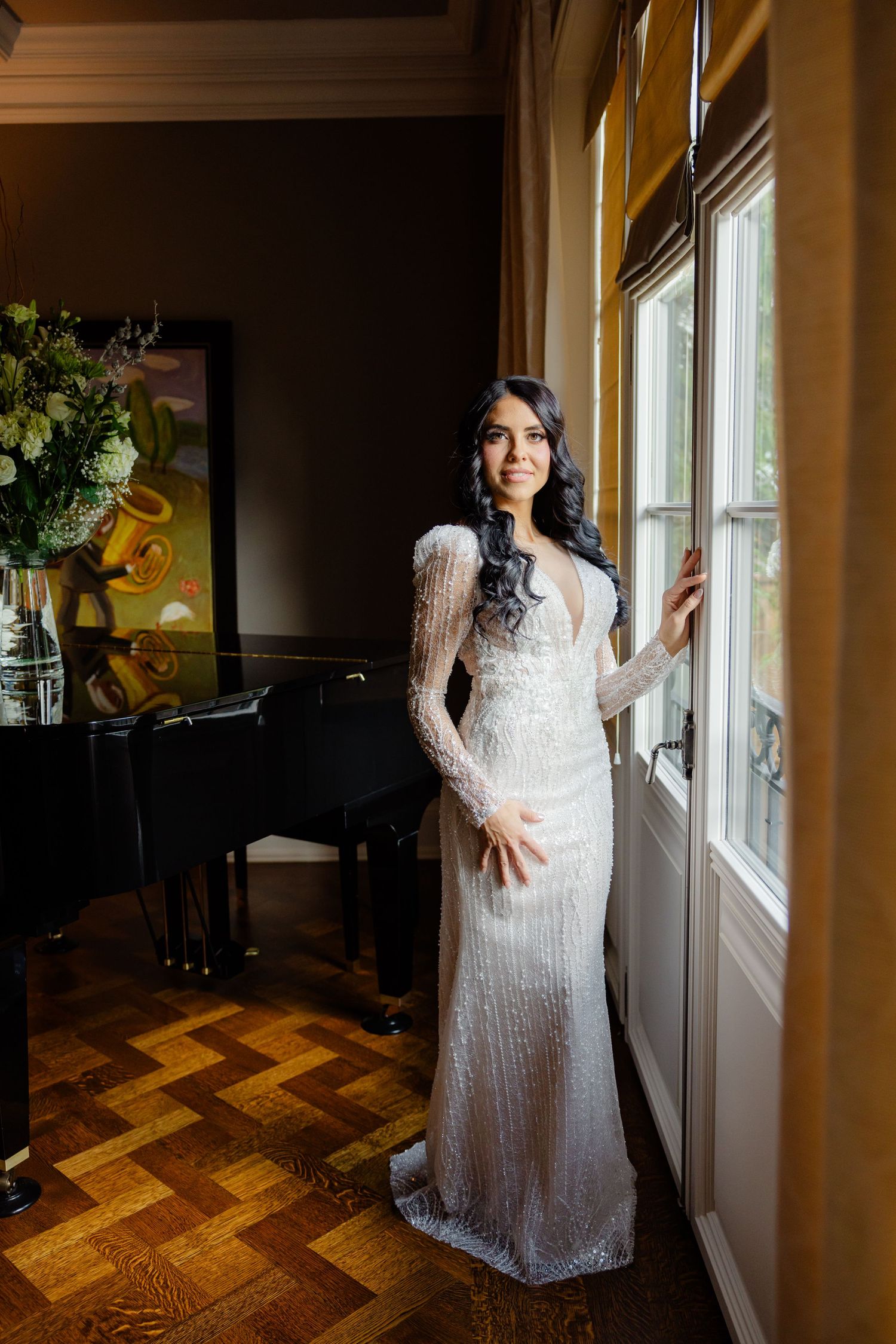 Full-length bridal portrait in an elegant room with parquet flooring and classic decor.