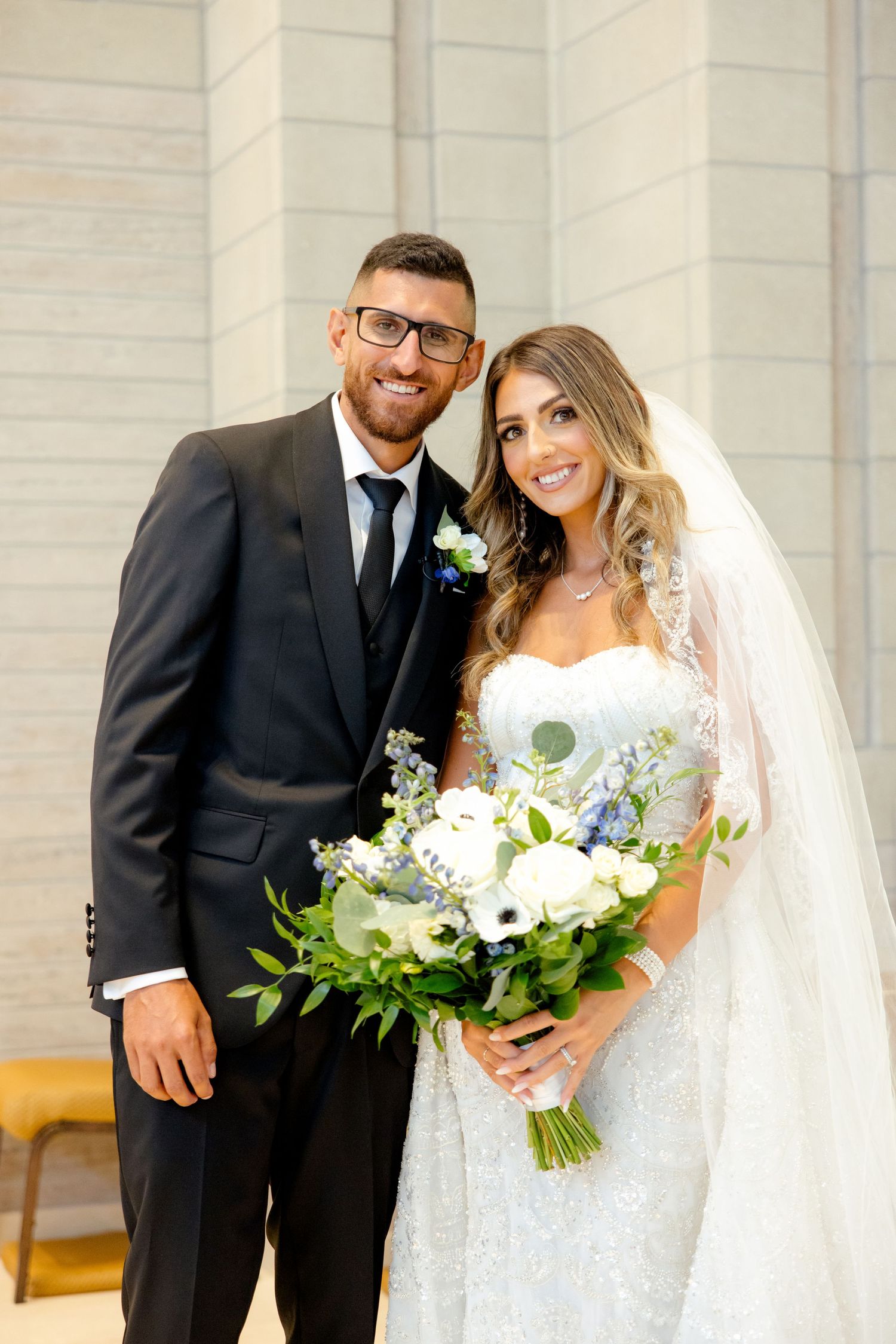 Wedding portrait featuring a sophisticated bouquet with white flowers and greenery.