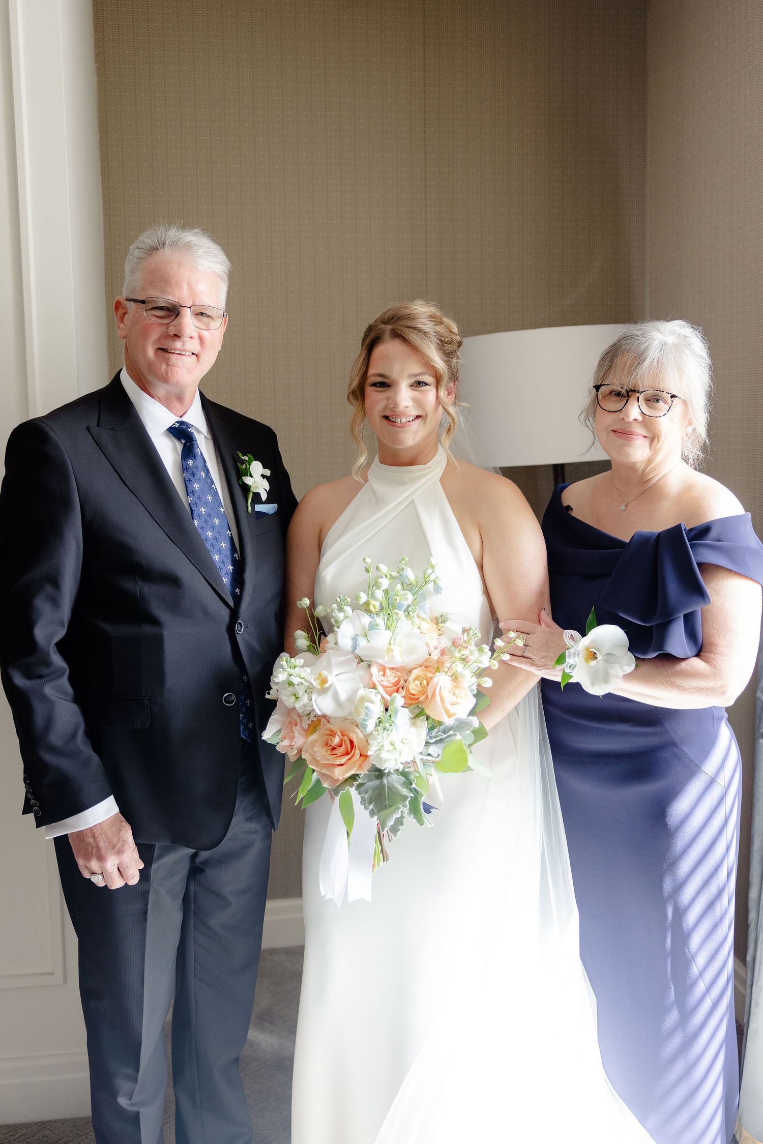 Series of elegant wedding portraits with bride in white gown and attendants in navy blue.