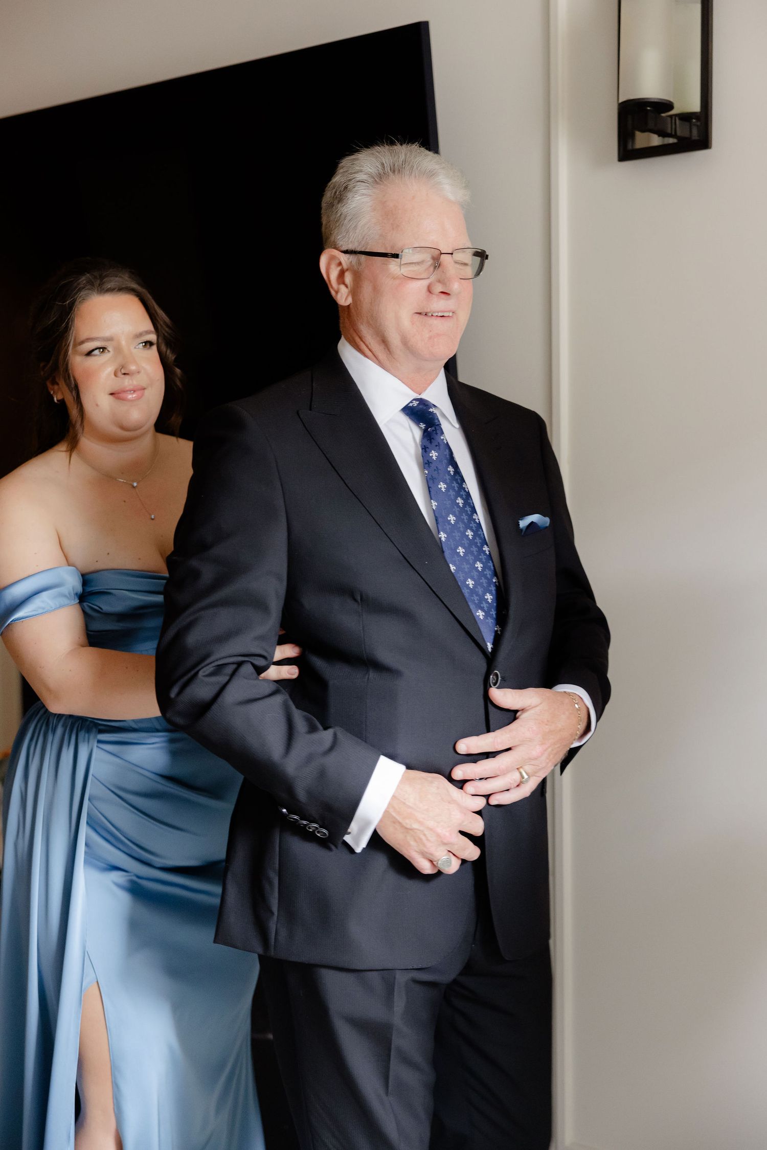 A touching first look moment between a couple at a wedding, with the bride in blue and groom in dark suit.