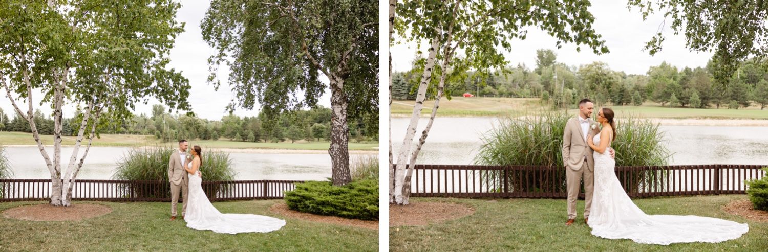 Wedding couple poses by a lakeside deck surrounded by birch trees and natural scenery.