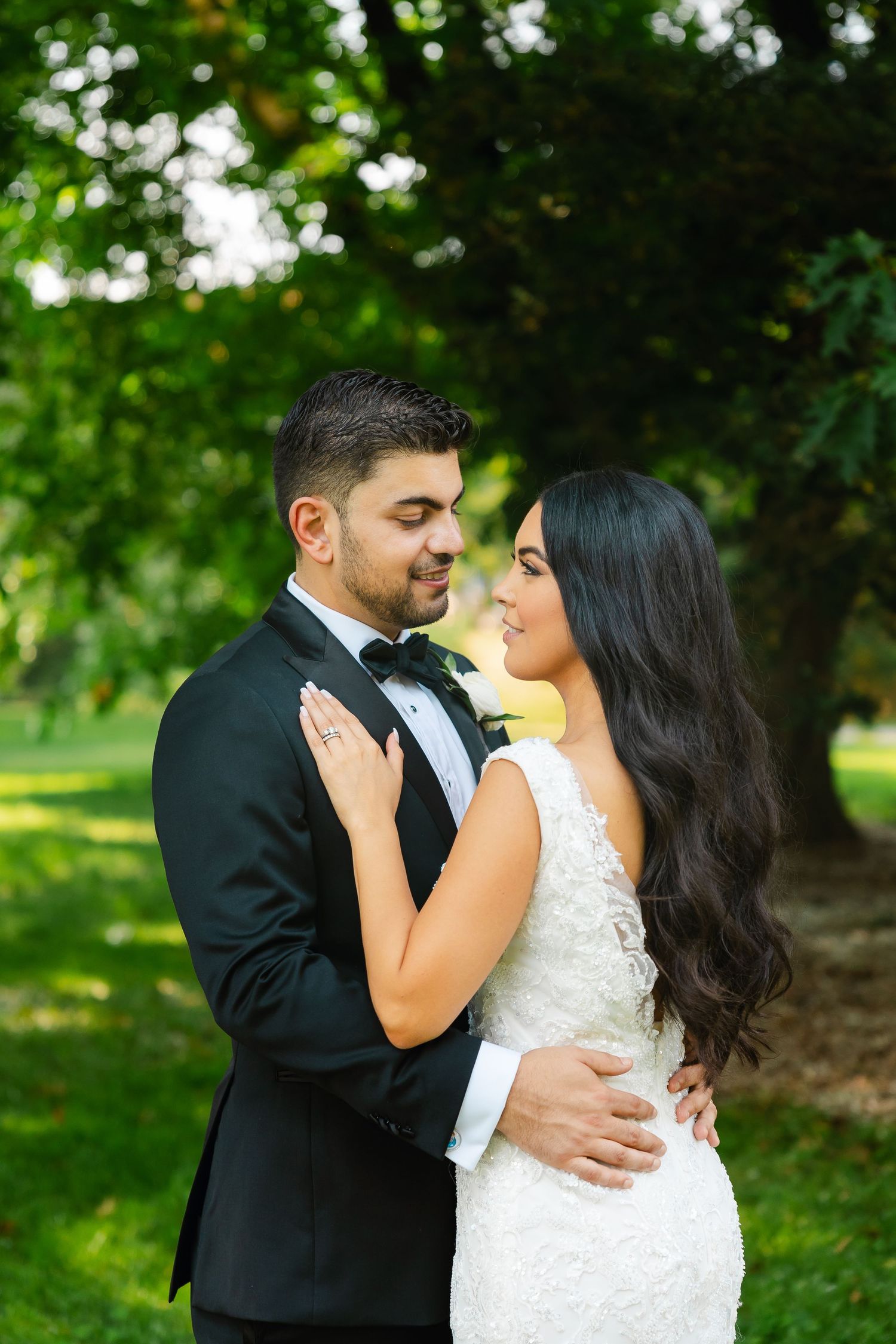 A tender wedding portrait of a couple in a garden setting with vibrant greenery.