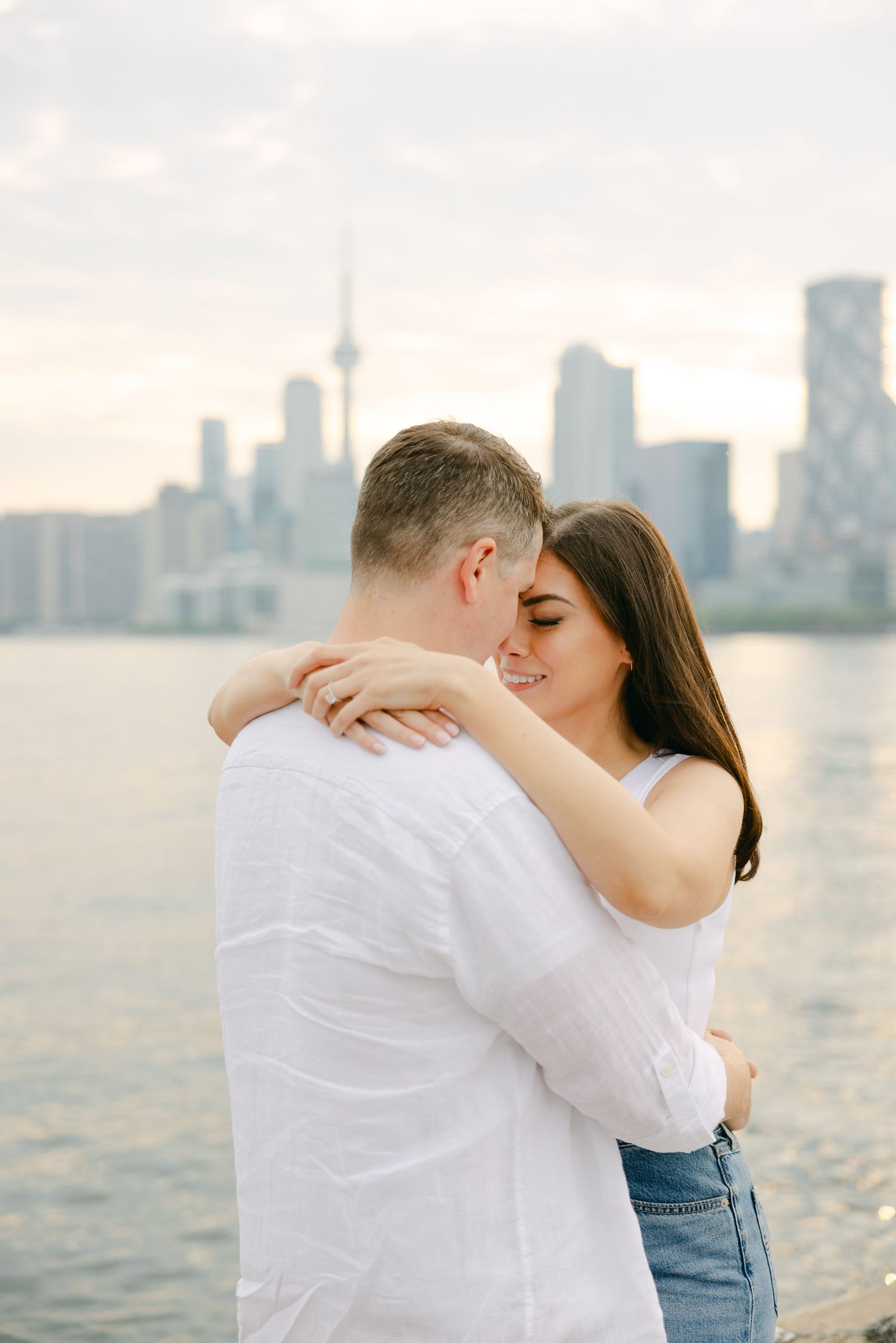 A sweet embrace photographed in soft light with Toronto's downtown skyline as backdrop.