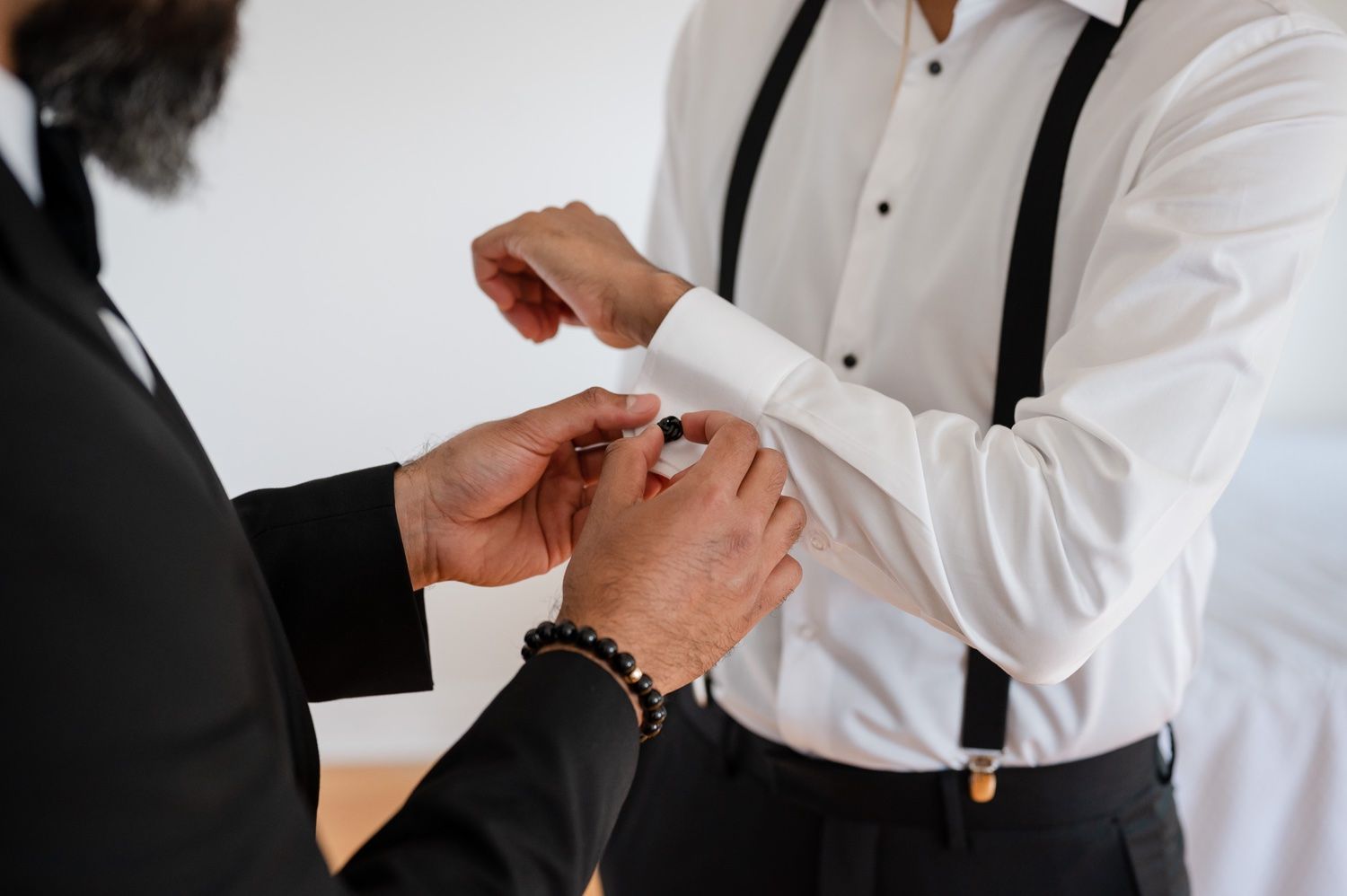 Close-up of hands adjusting formal wear during wedding preparations.