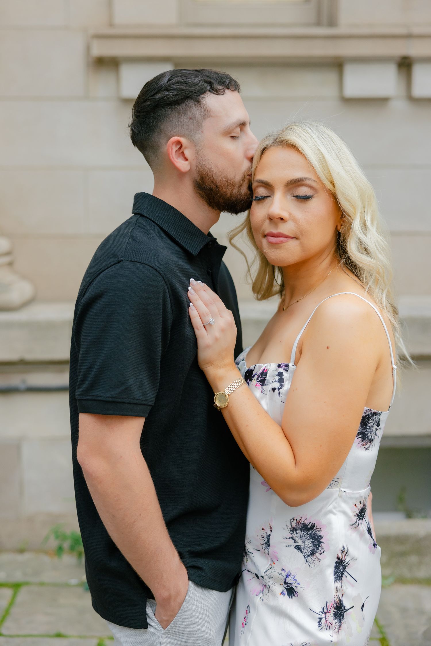 Intimate moment between couple against architectural backdrop.