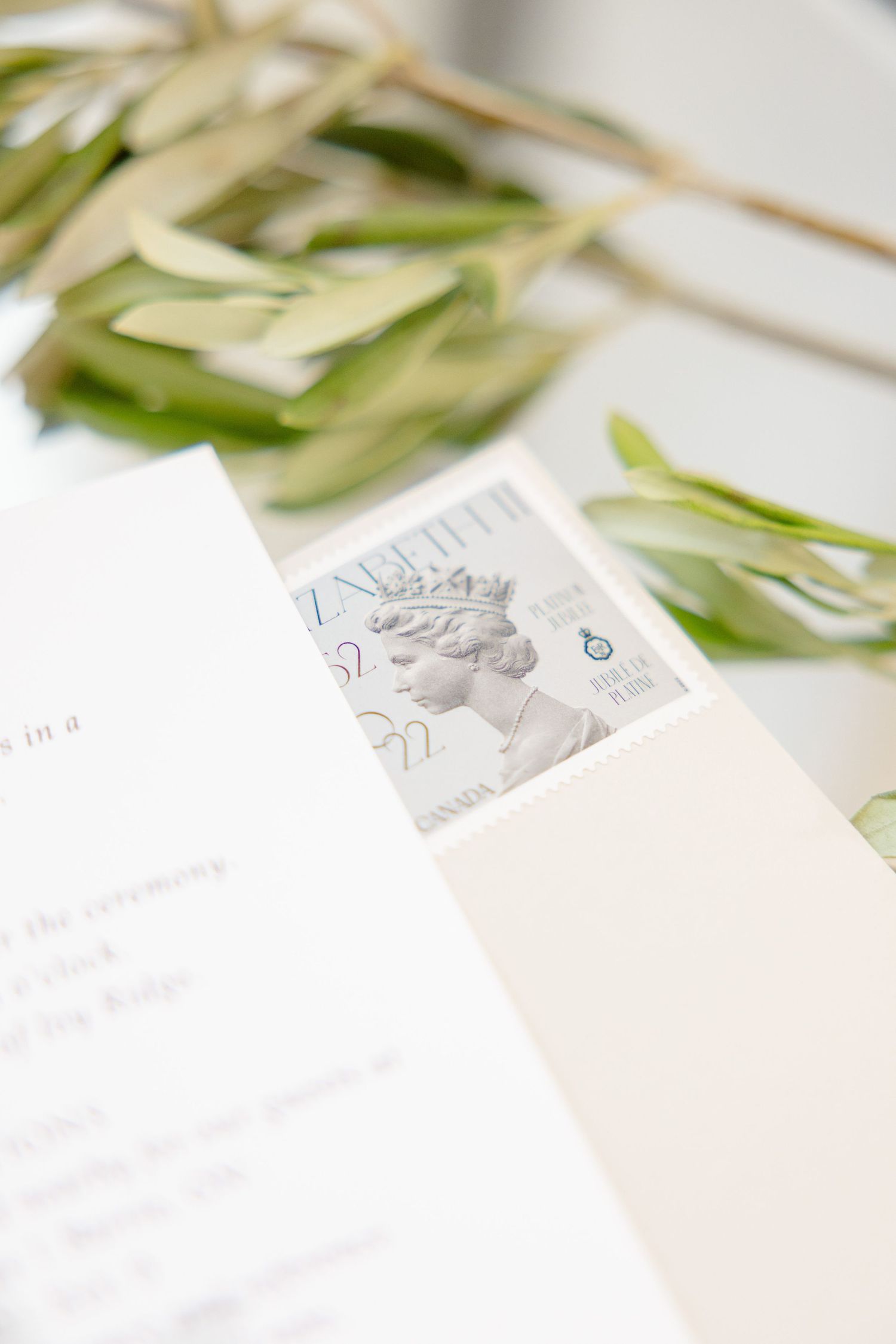 Vintage postage stamp featuring Queen Elizabeth II on elegant wedding stationery with green foliage.