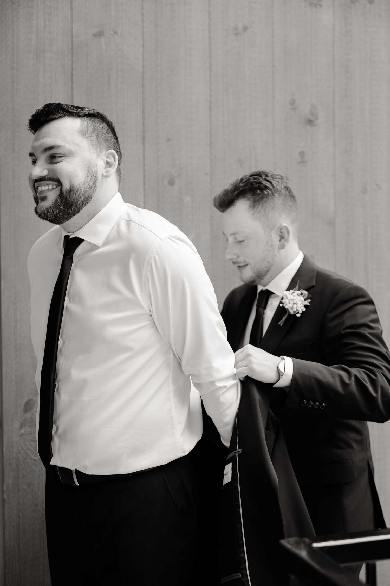Two people in formal wear sharing a candid moment on wedding day.
