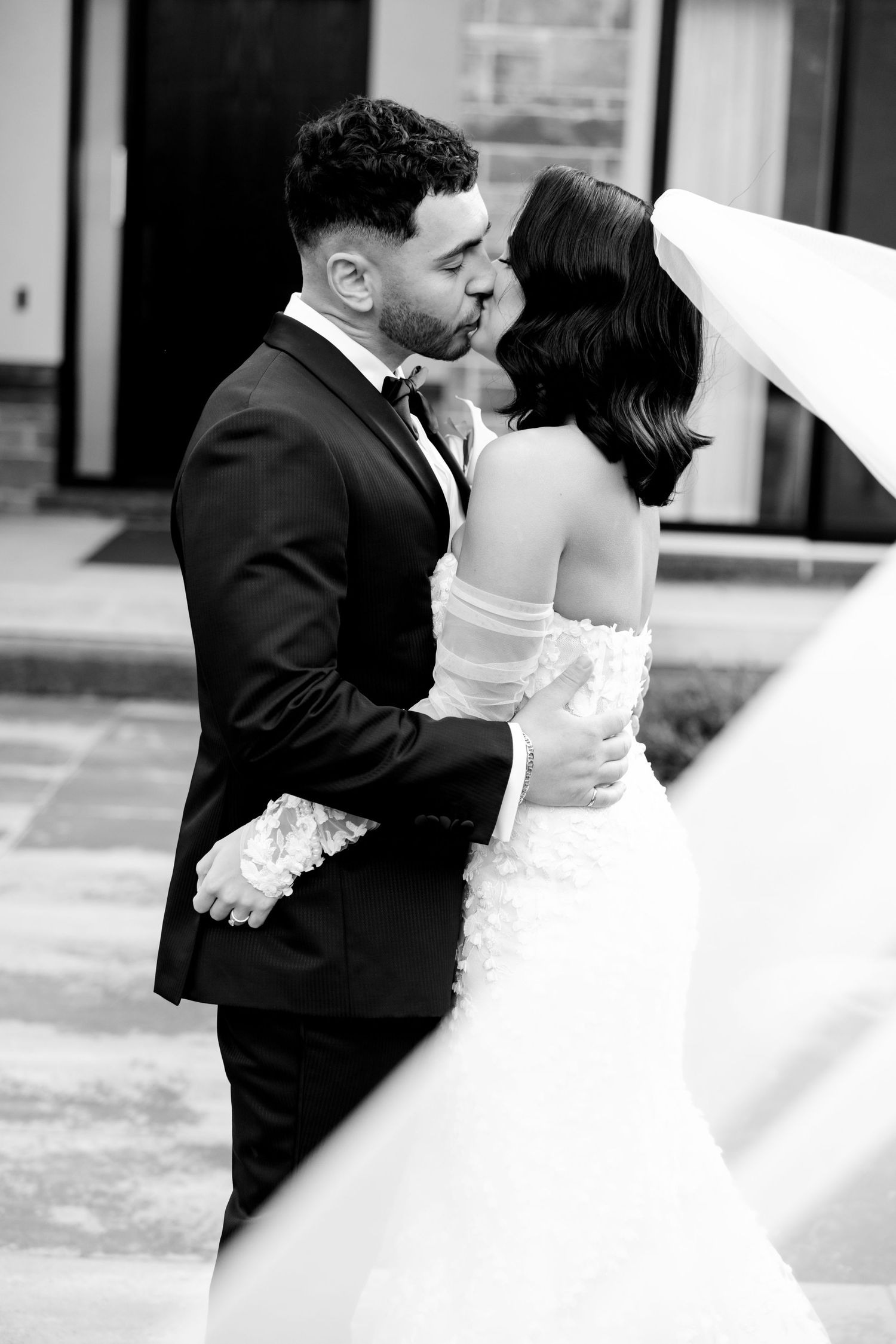 Black and white portrait of newlyweds sharing a tender moment during their wedding photoshoot.