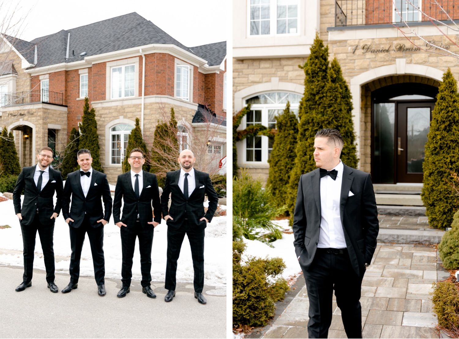 A group of groomsmen in black tuxedos pose outside a brick mansion with manicured shrubs.