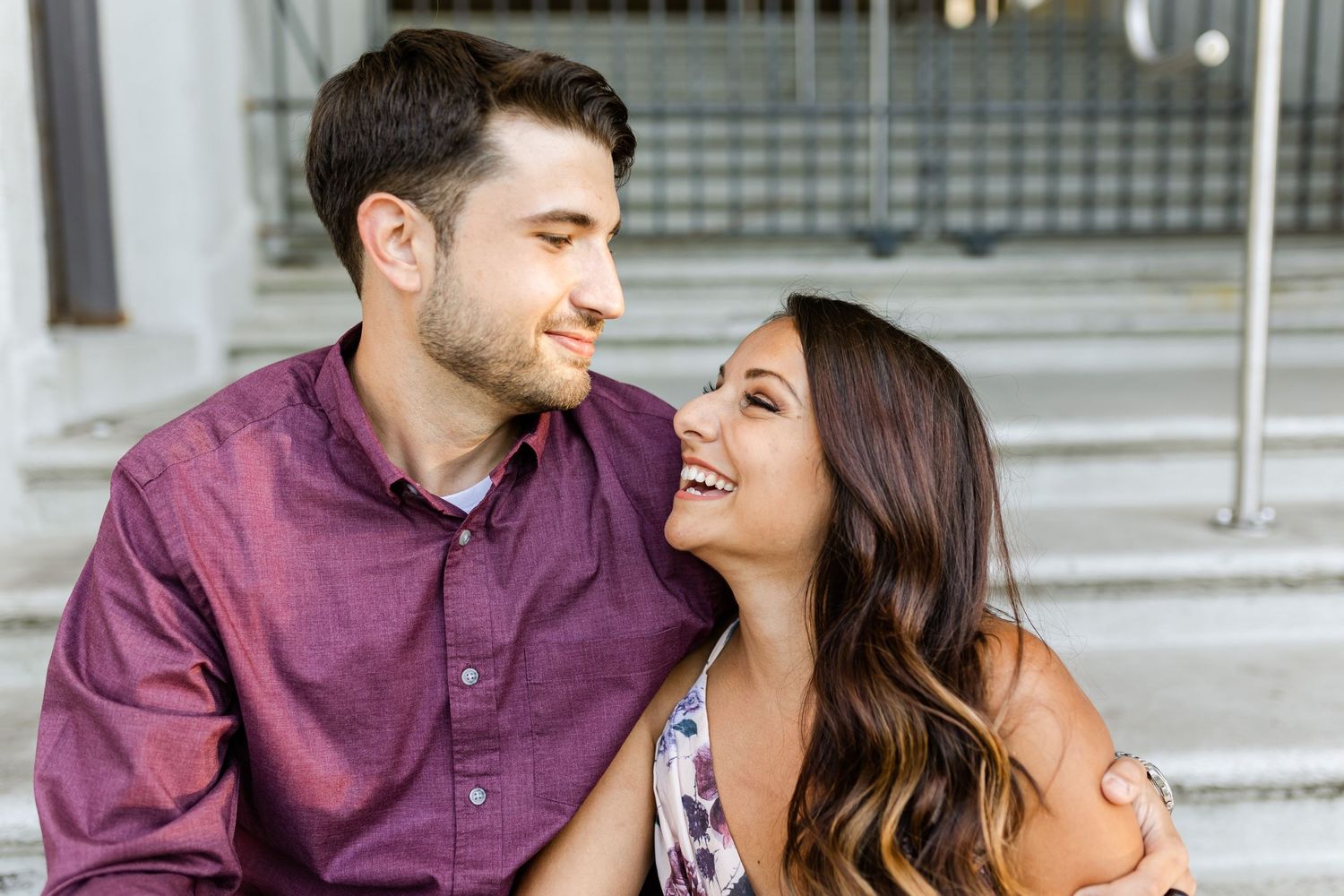 Close up of couple sharing a laugh while sitting together on steps.