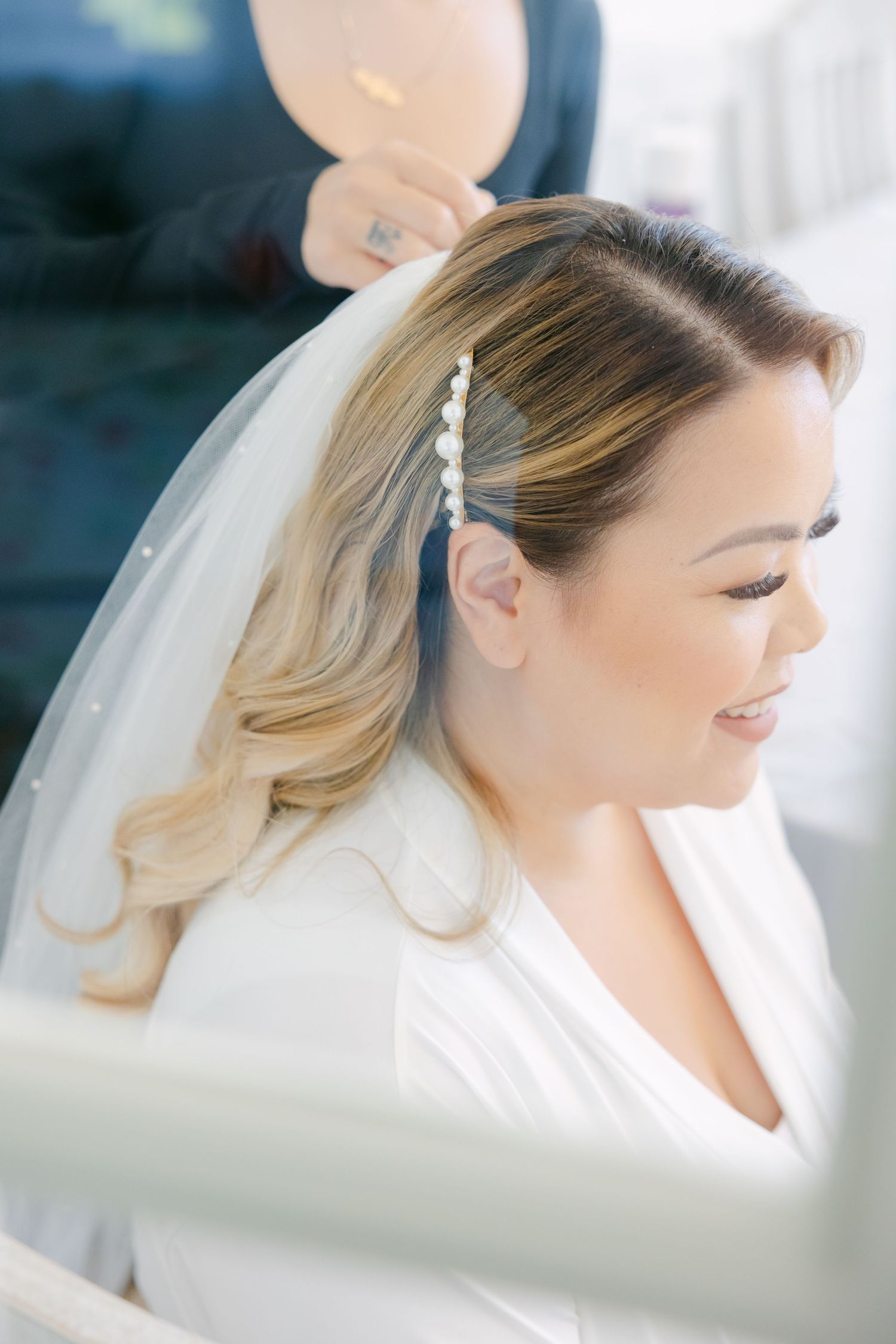 Close up side profile of bride with pearl hair accessory and delicate veil.
