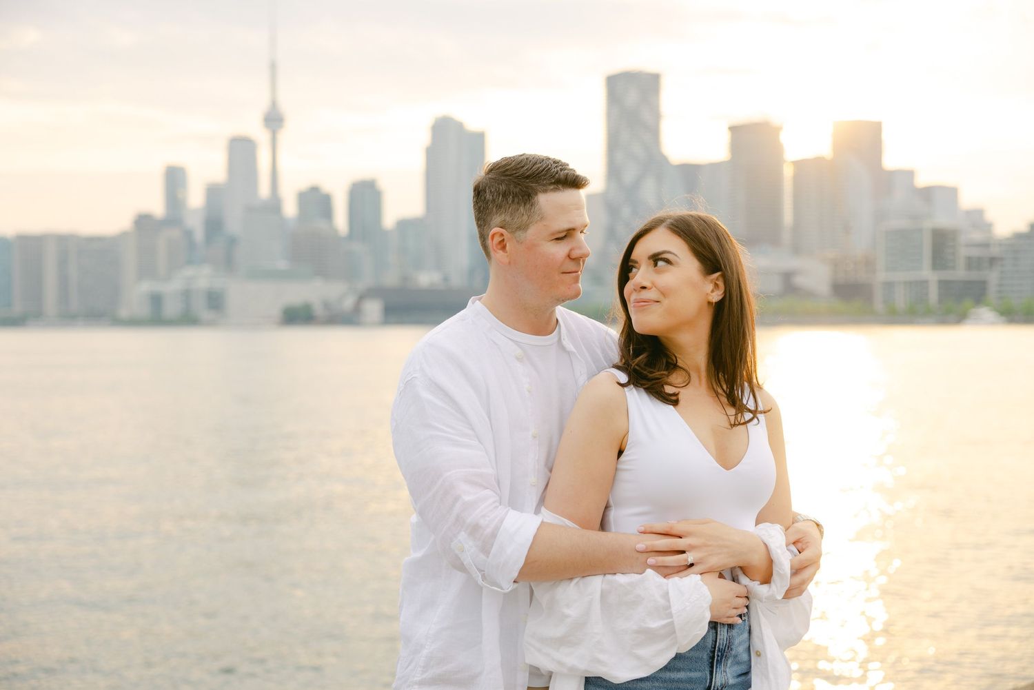 Romantic sunset photoshoot with Toronto skyline creating perfect backdrop for couple.