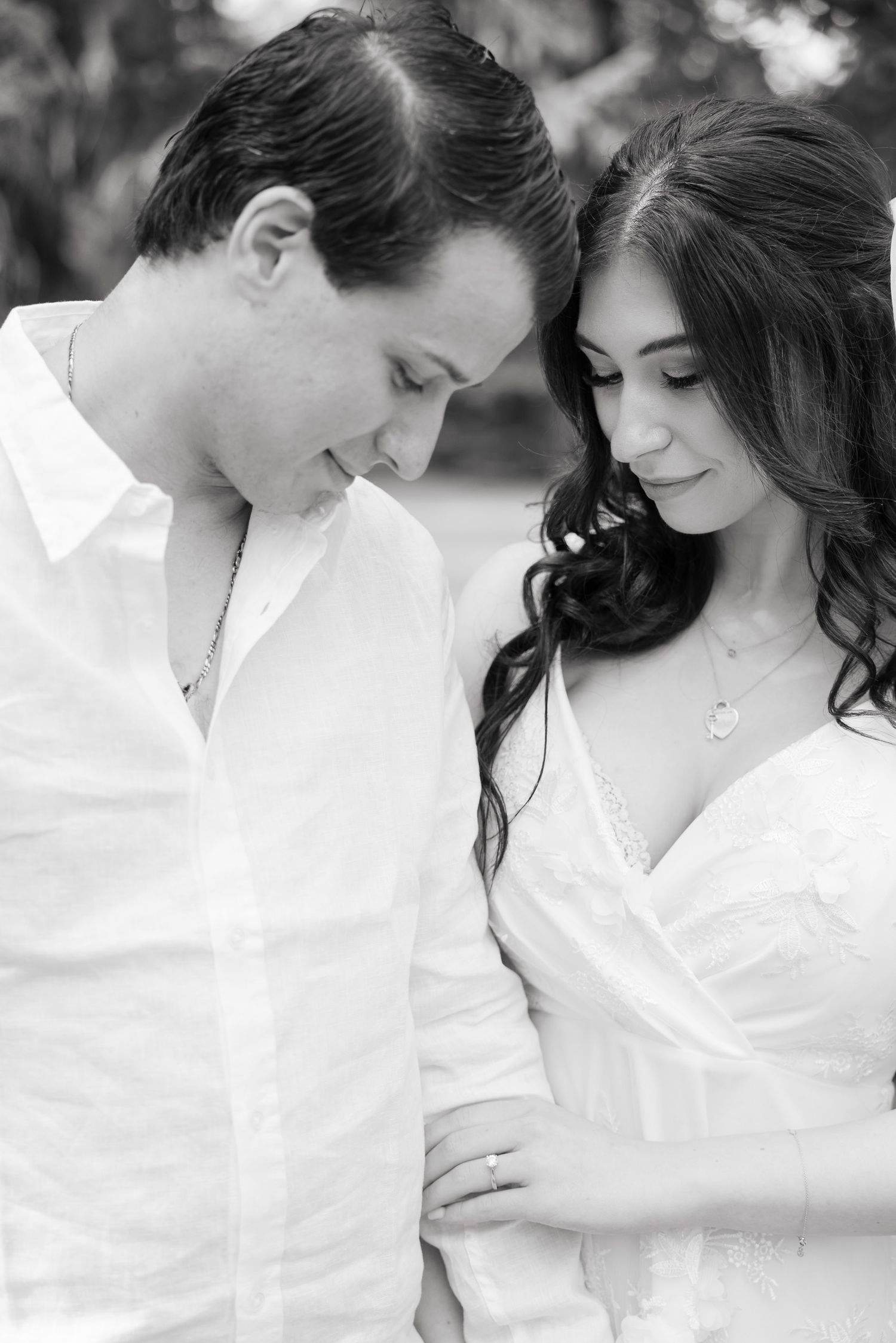A close-up black and white portrait of a couple sharing a romantic moment during their wedding photoshoot.
