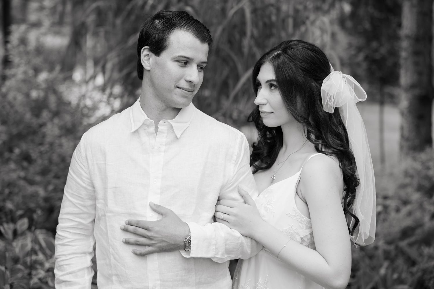 A black and white wedding portrait capturing a tender moment between a couple.