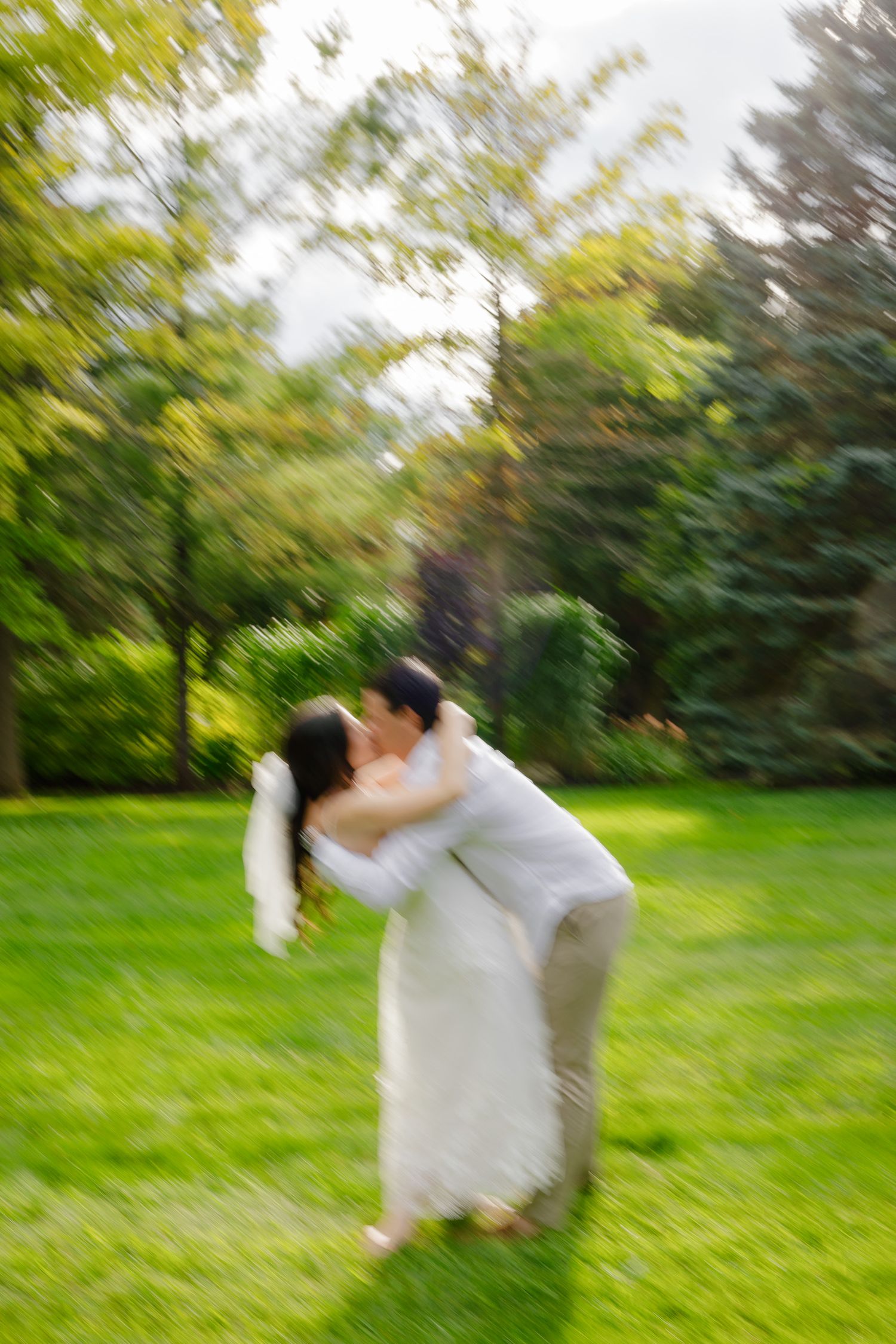 A blurry candid moment of dancing in a lush garden setting.