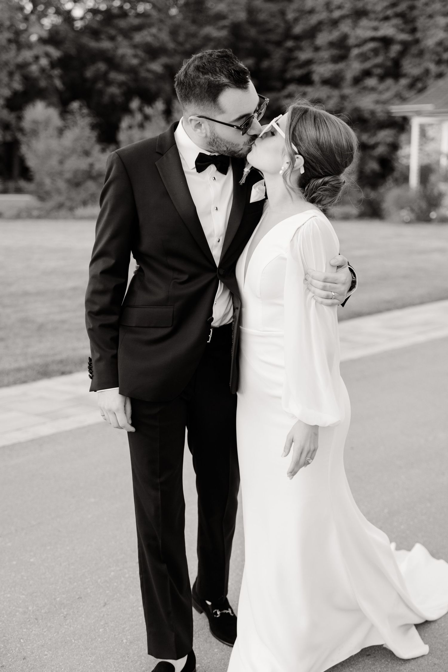 An intimate black and white wedding portrait of a couple sharing a tender moment.