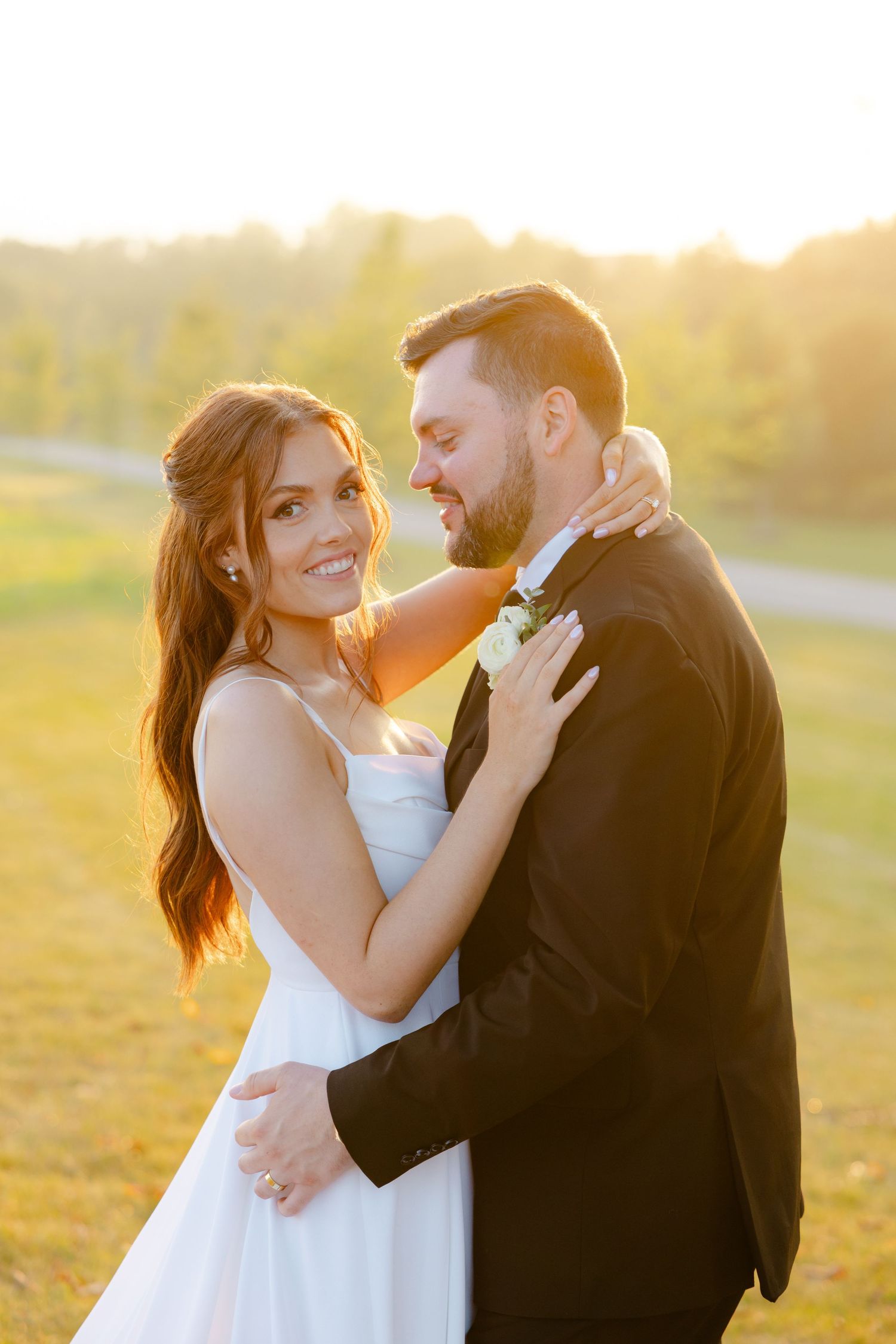 Sunset wedding photoshoot features couple in classic formal attire sharing a romantic moment outdoors.