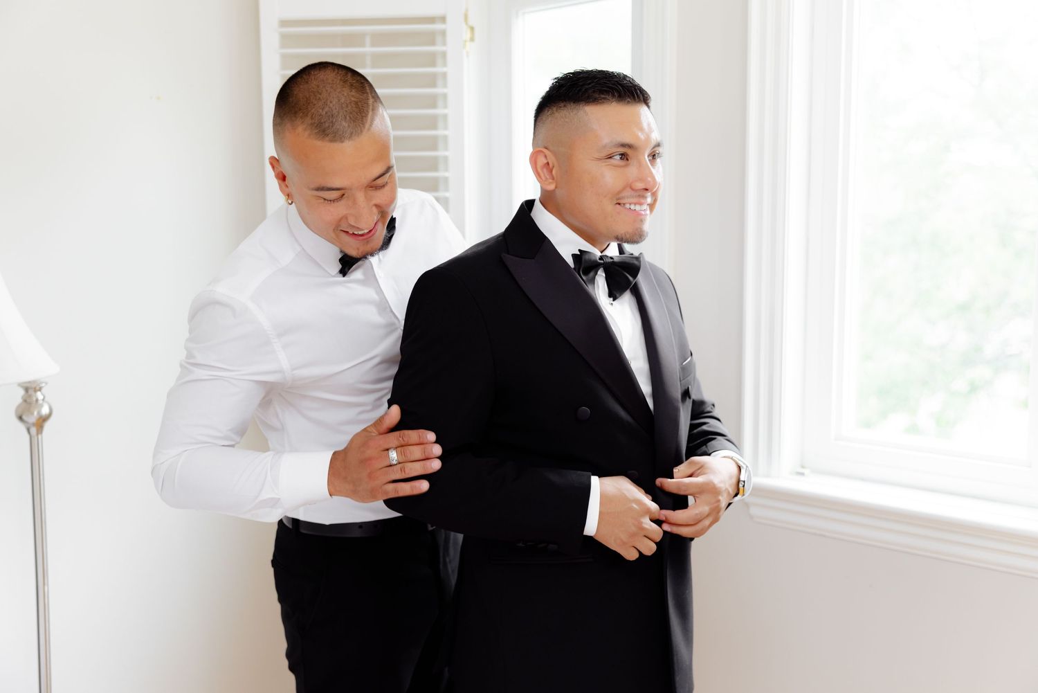 A group of people in formal black and white attire toast with champagne flutes at an elegant celebration.