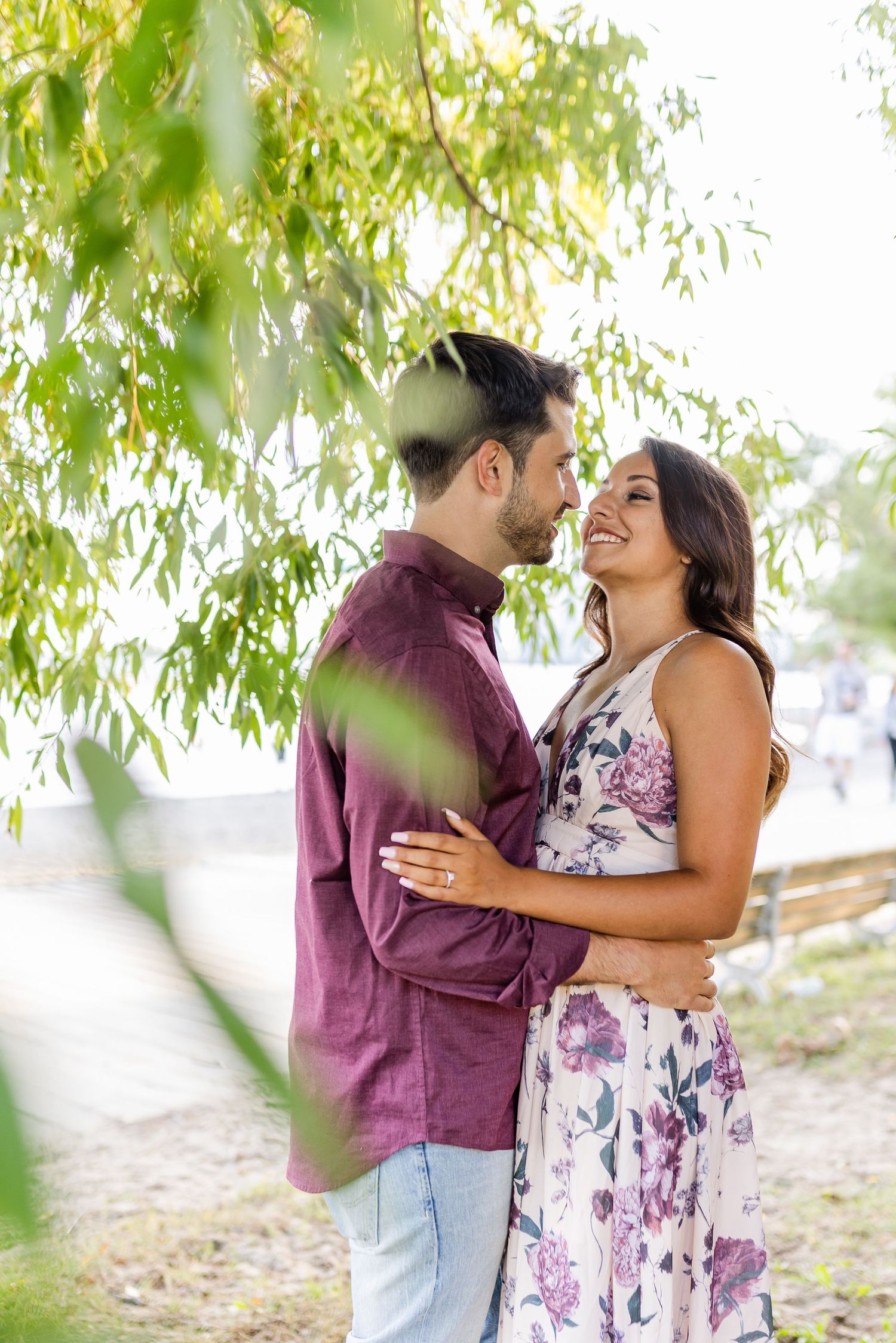 Romantic couple sharing intimate moment under hanging willow branches.