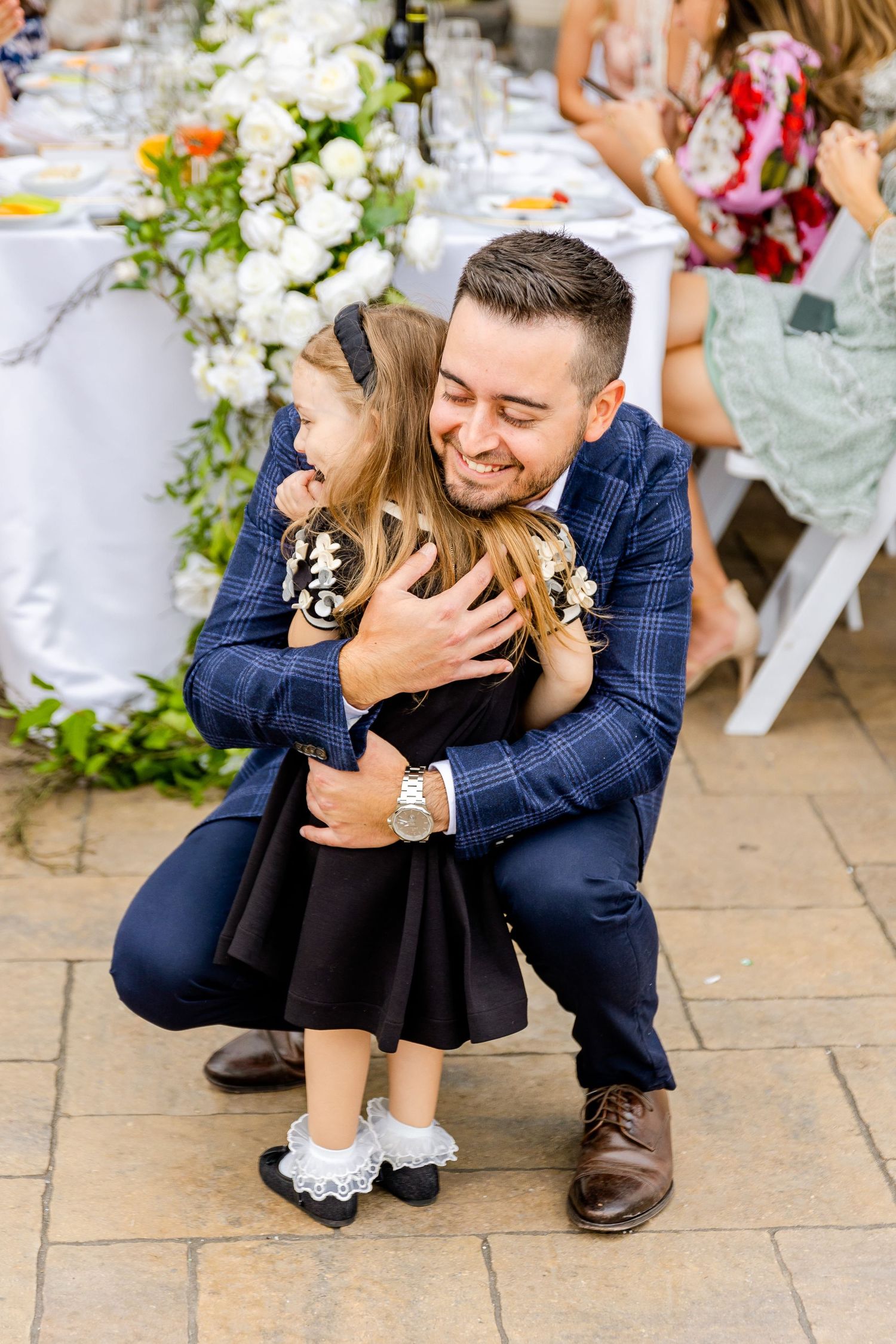 A tender moment between guests at an elegantly decorated outdoor event.