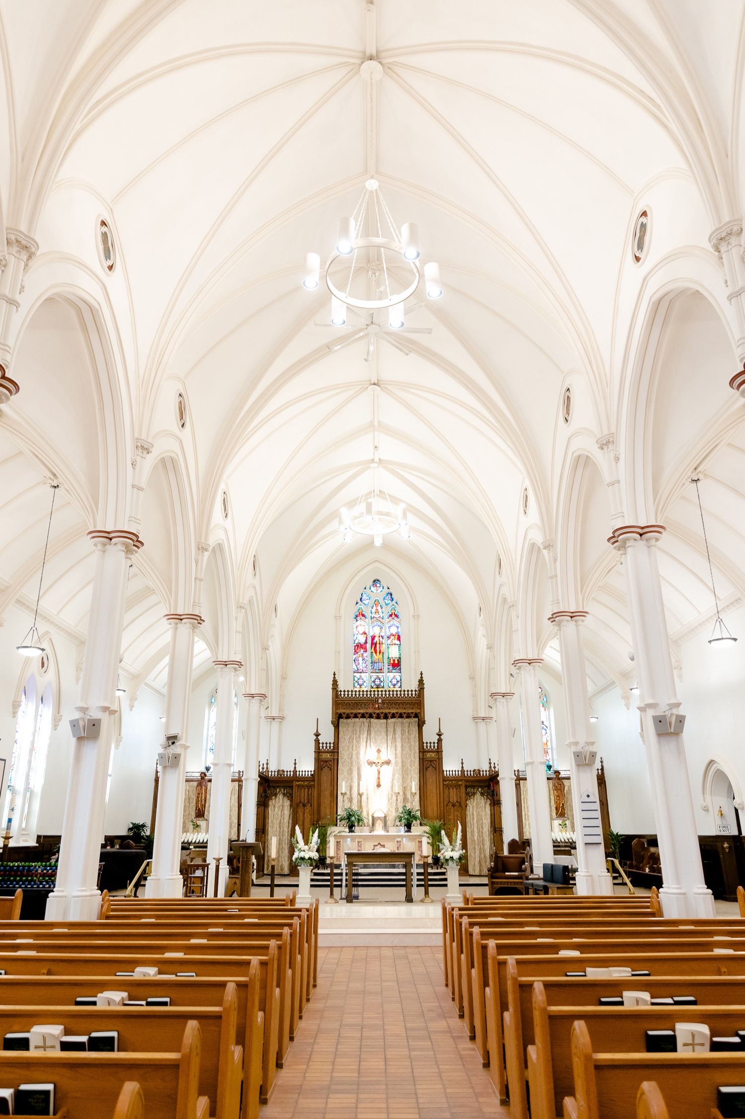 Majestic cathedral interior with vaulted ceilings, wooden pews and grand altar.