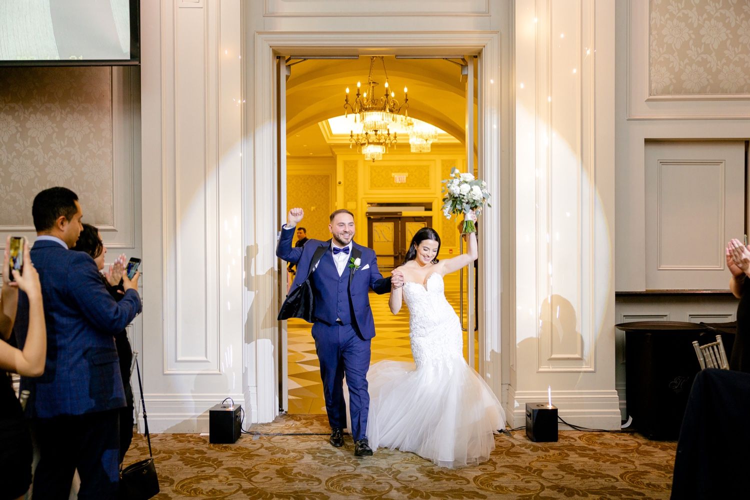 Wedding celebration entrance with couple entering through illuminated doorway.