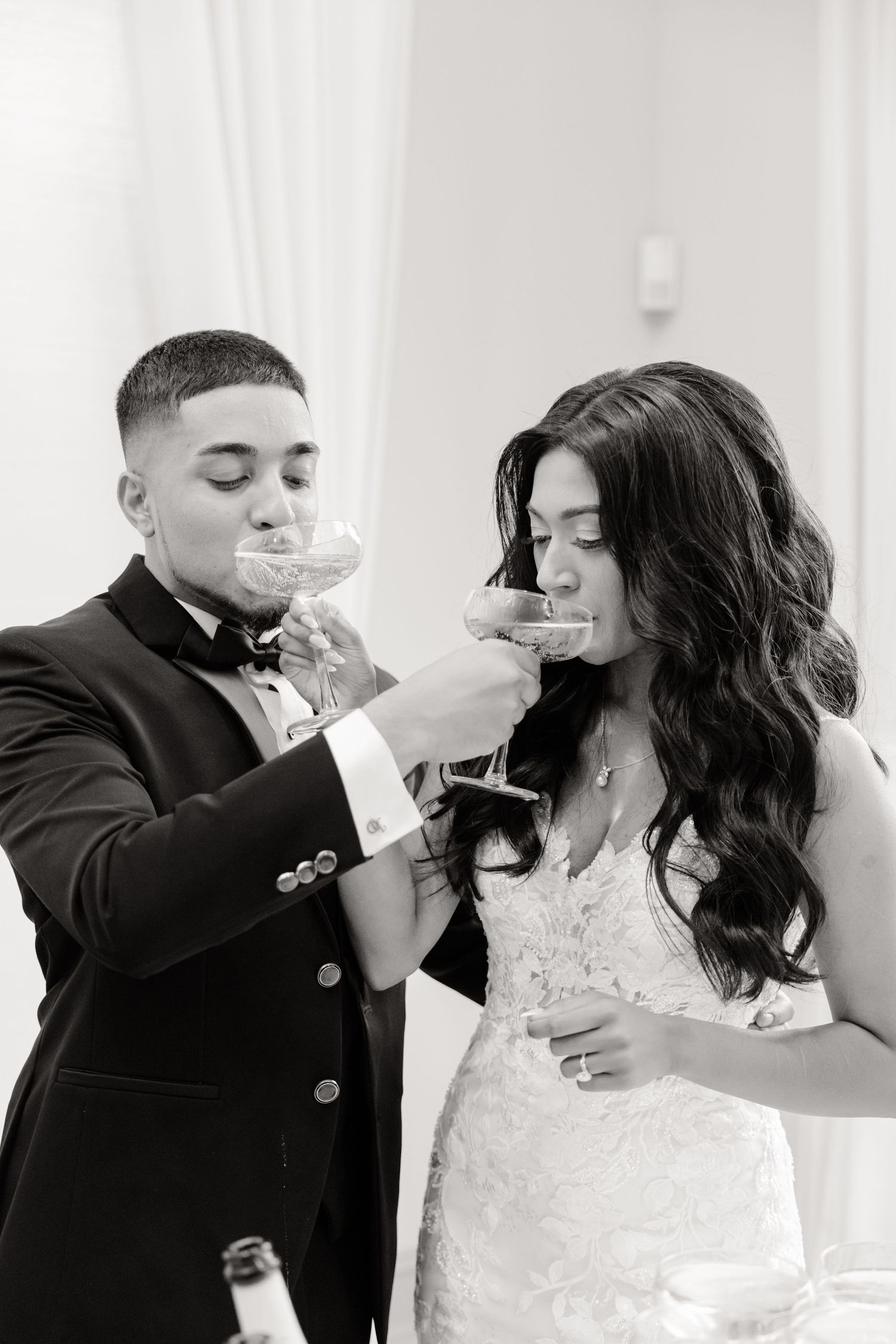 A couple dances together during their wedding reception with guests watching in the background.