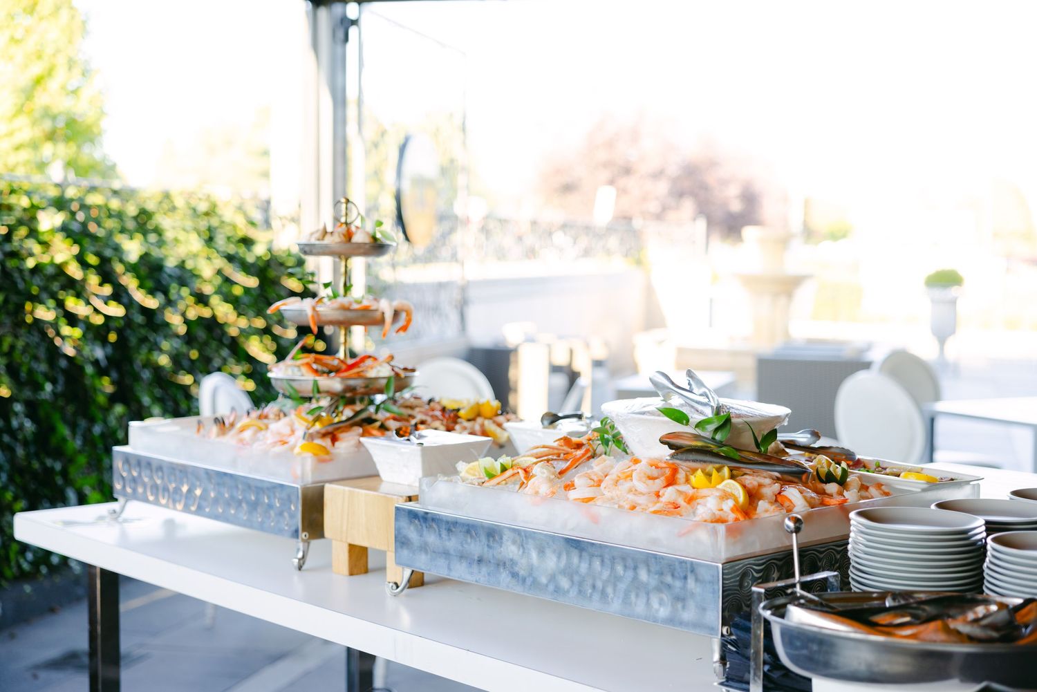 Outdoor wedding reception buffet setup with seafood and appetizers.