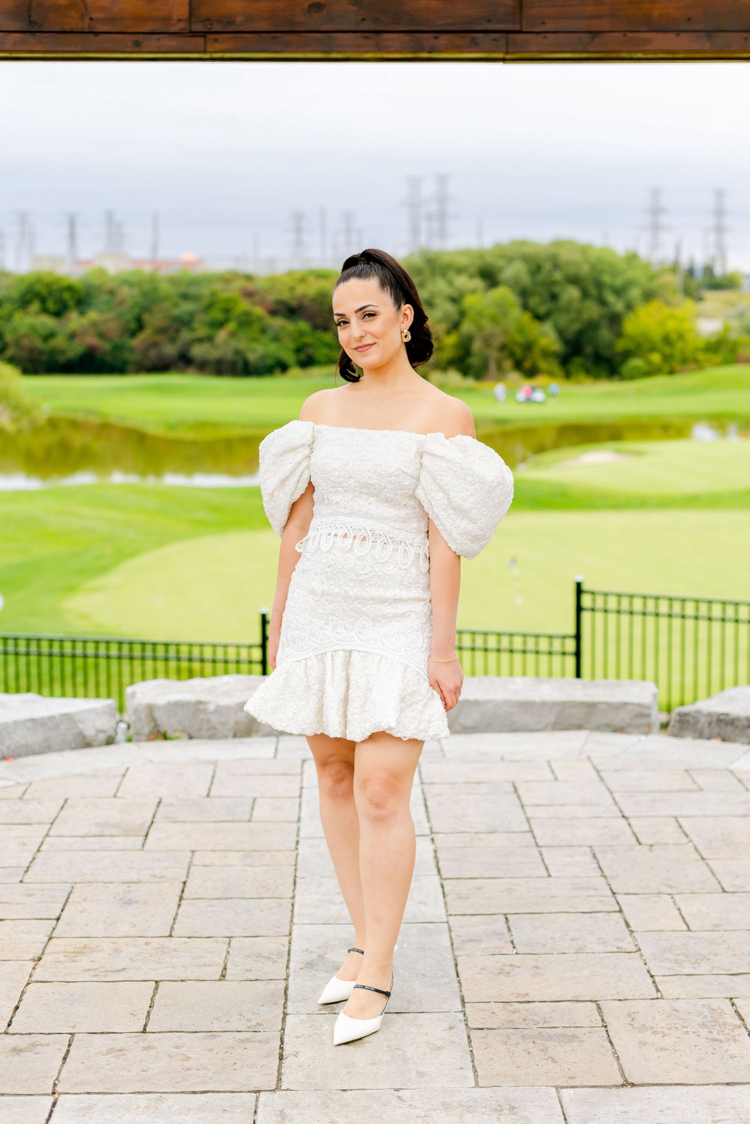 Modern bridal fashion shoot on stone patio with golf course scenery in background.