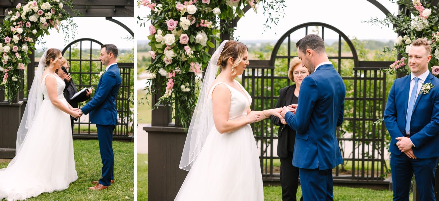 Exchange of rings during outdoor wedding ceremony beneath floral-decorated pergola.