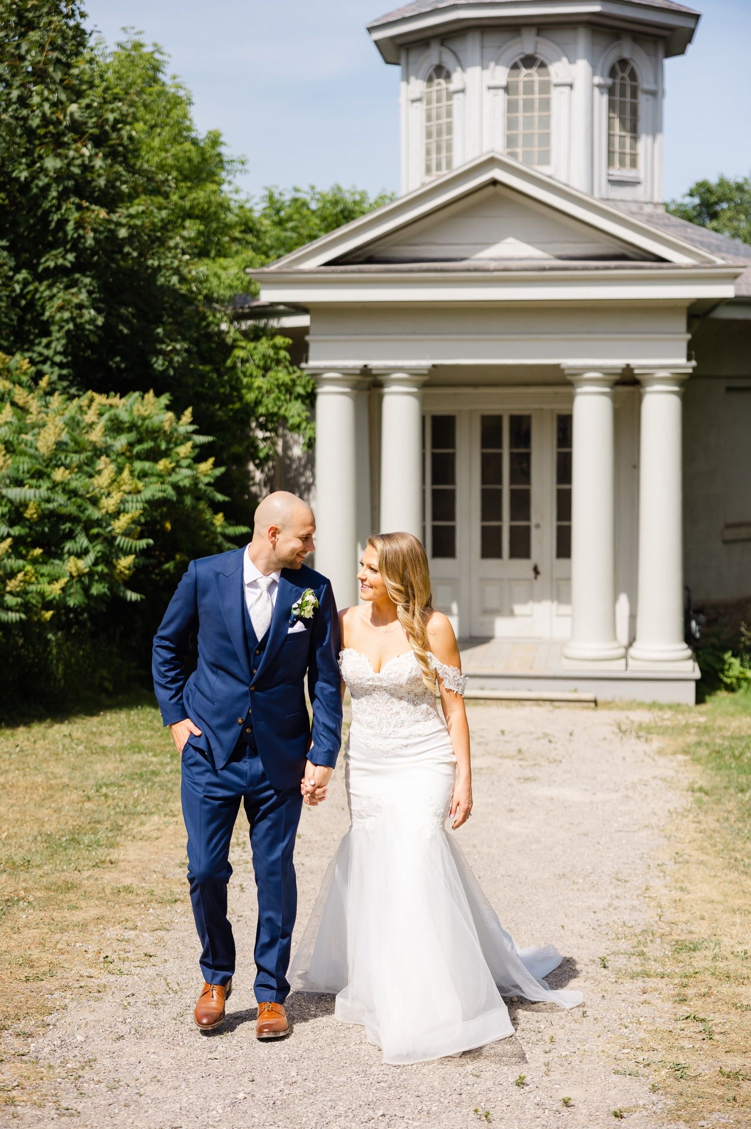 Couple standing in front of historic white building with classical architecture.